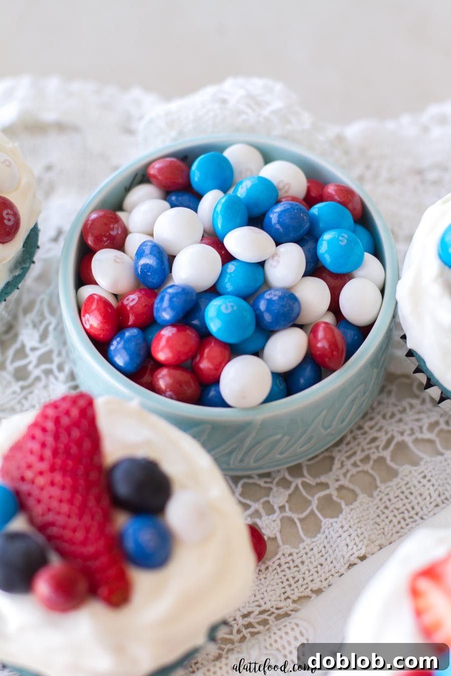 A close-up of the interior of a sliced red, white, and blue velvet cupcake, revealing the distinct colored layers.