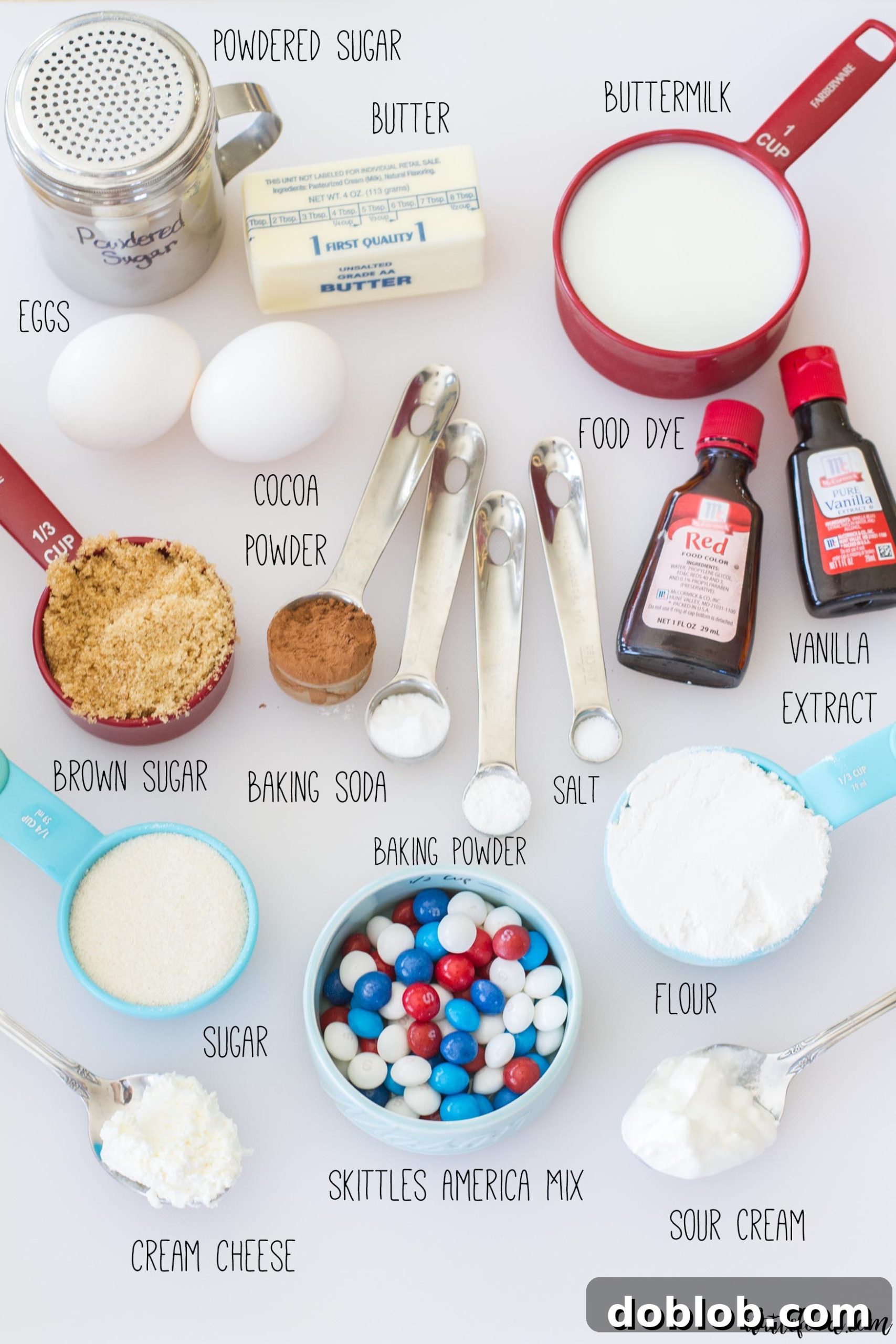 Assortment of patriotic-themed baking ingredients, including Skittles America Mix, fresh berries, and baking tools.