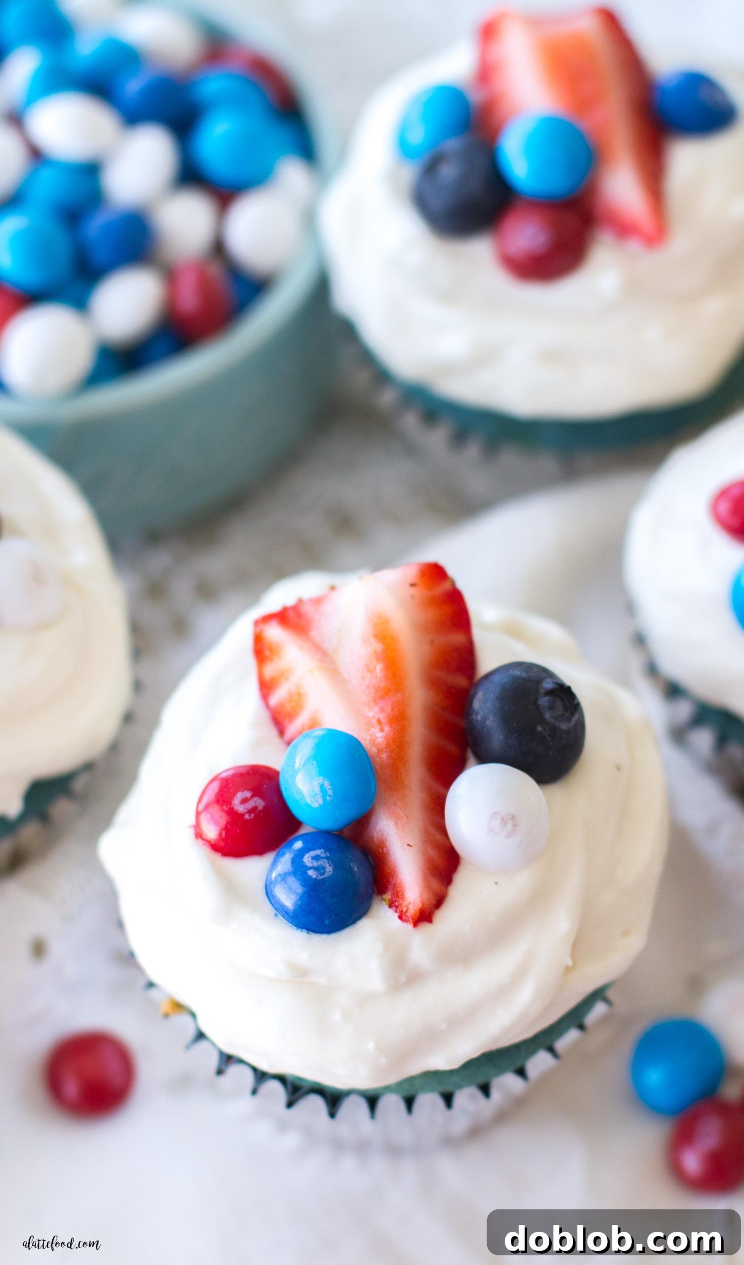 A hands-on shot showing the red, white, and blue cake batter being prepared in separate bowls.
