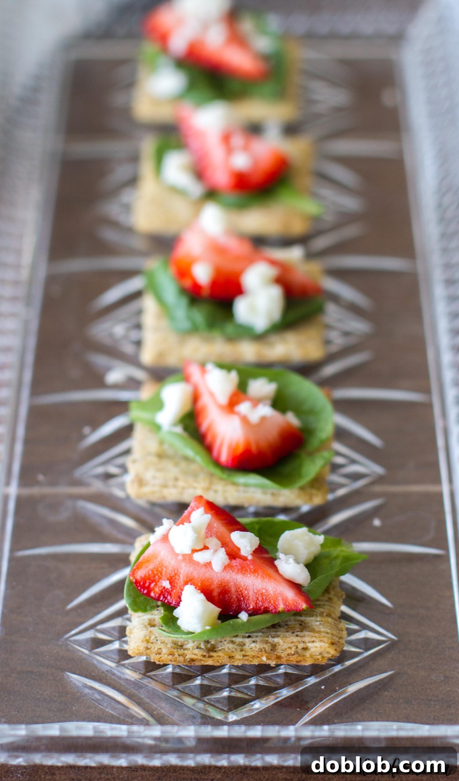 A close-up view of the quick and easy Spinach, Strawberry, and Feta TRISCUIT appetizer, highlighting the textures and colors.