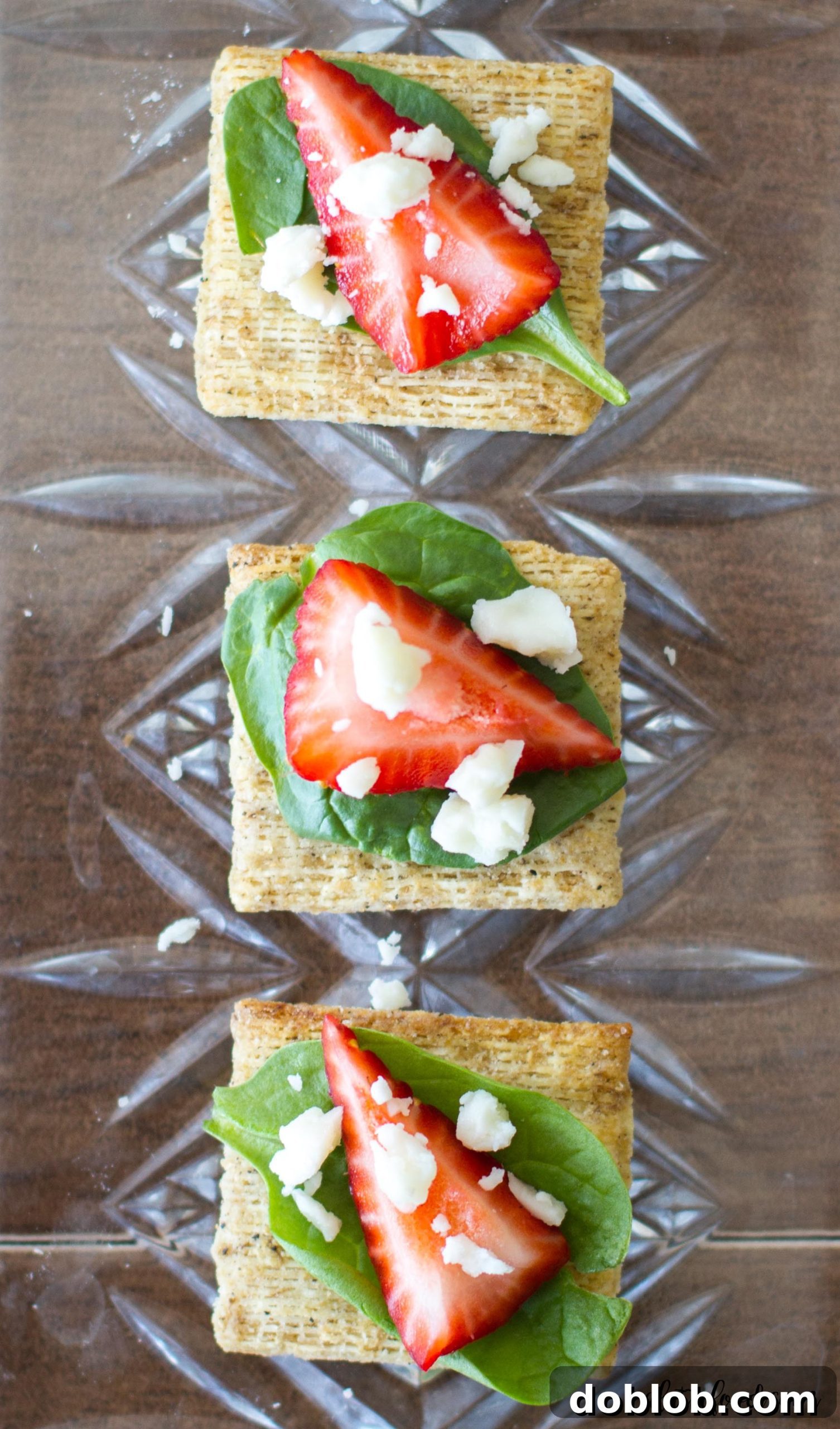 Another perspective of the colorful and inviting Spinach, Strawberry, and Feta TRISCUIT crackers, perfect for any gathering.