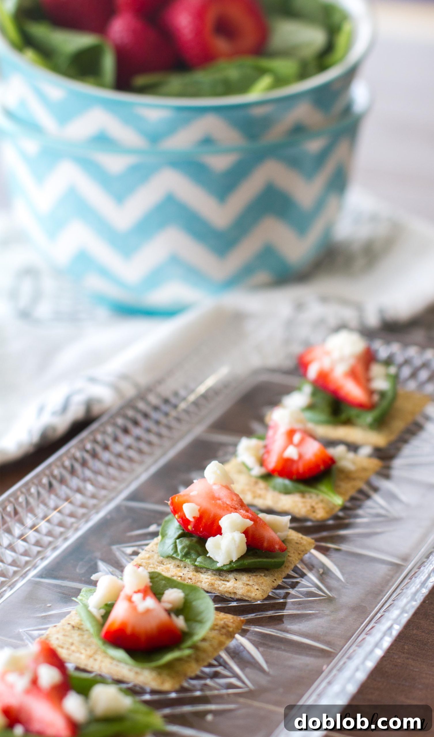 A selection of Spinach, Strawberry, and Feta appetizers artfully arranged on a rustic wooden board, emphasizing natural presentation.