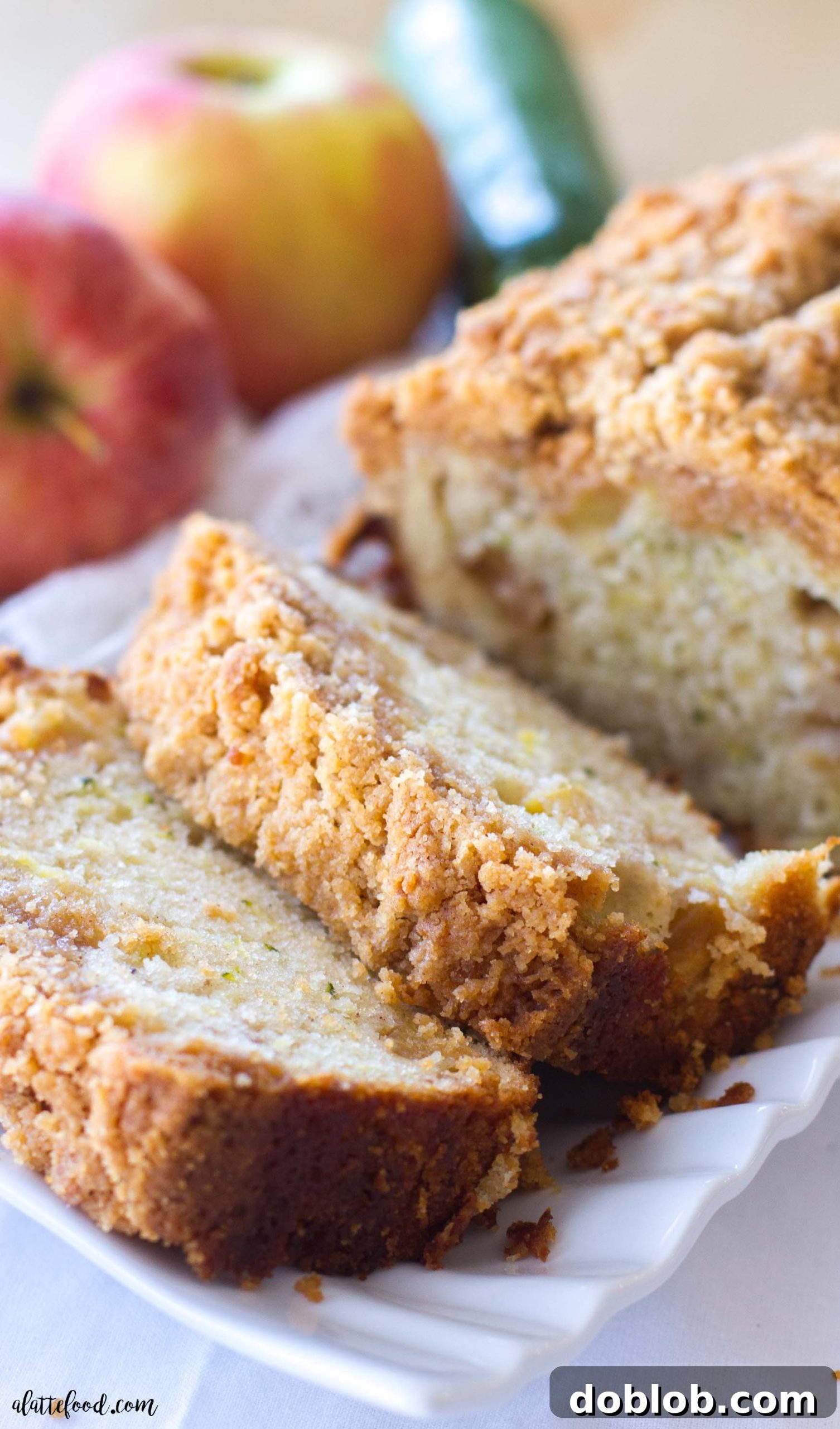A close-up shot of a single loaf of Zucchini Apple Crumb Bread, highlighting the rich texture of the crumb topping before slicing.