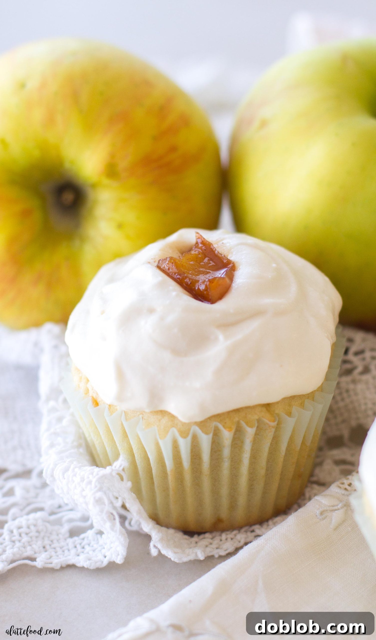 Spiced Apple Delights 7 A top-down view of an apple pie cupcake on a rustic wooden surface, highlighting the detailed frosting and apple garnish.