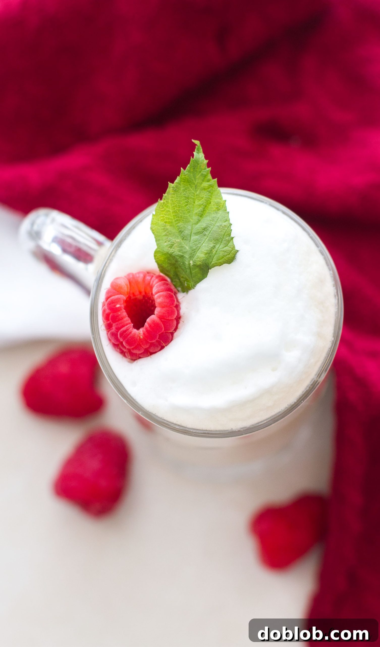 A close-up of a White Chocolate Raspberry Vanilla Latte, showcasing its creamy texture and inviting layers, ready to be enjoyed.