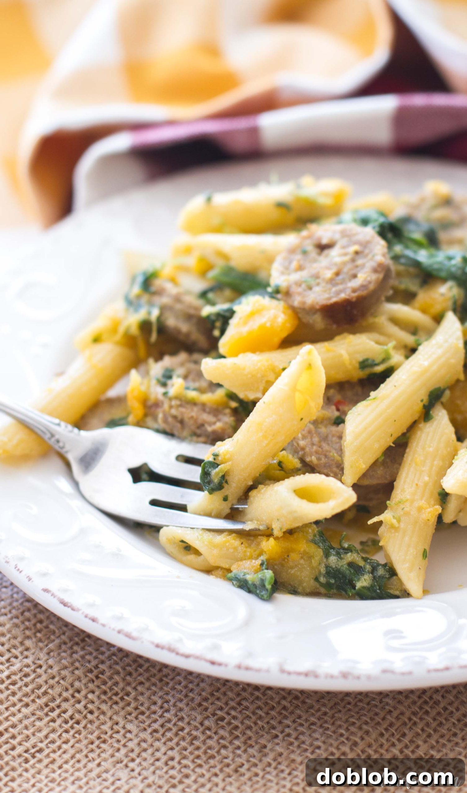 Butternut Squash, Spinach, & Johnsonville Sausage Penne pasta served in a rustic bowl.