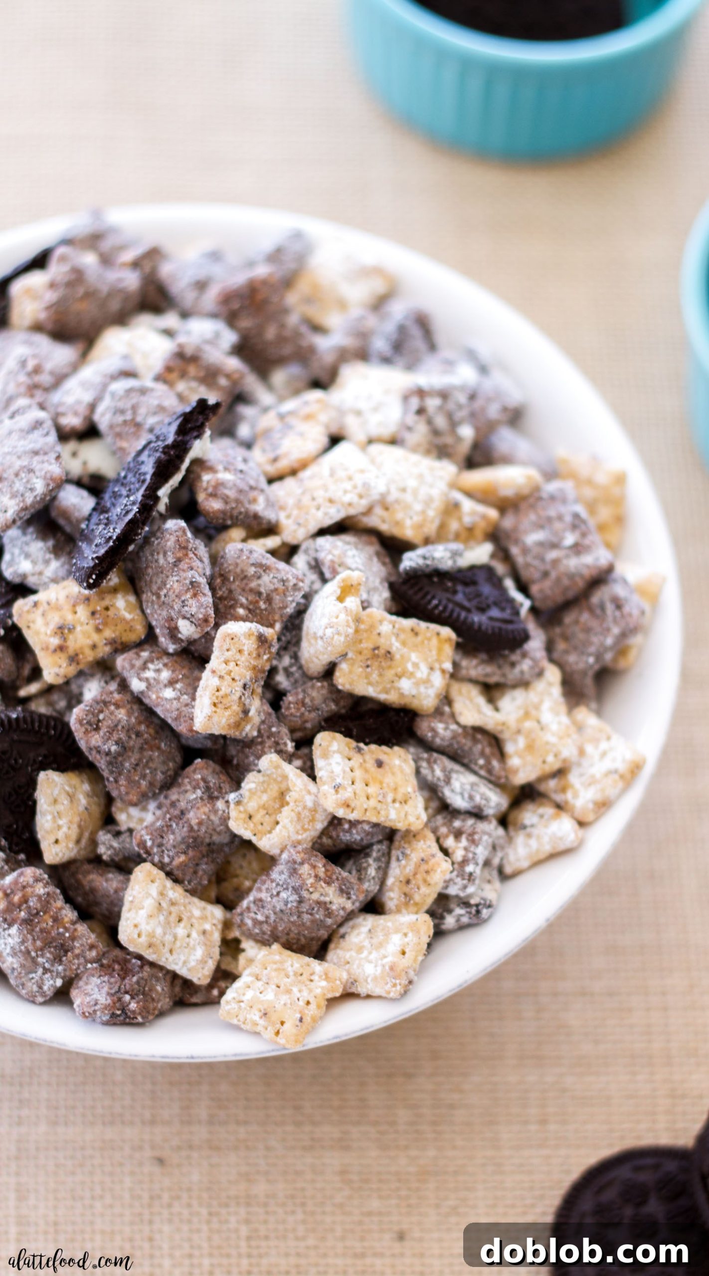 Close-up of Salted Caramel Cookies 'n Cream Muddy Buddies, showcasing the powdered sugar and Oreo crumbs