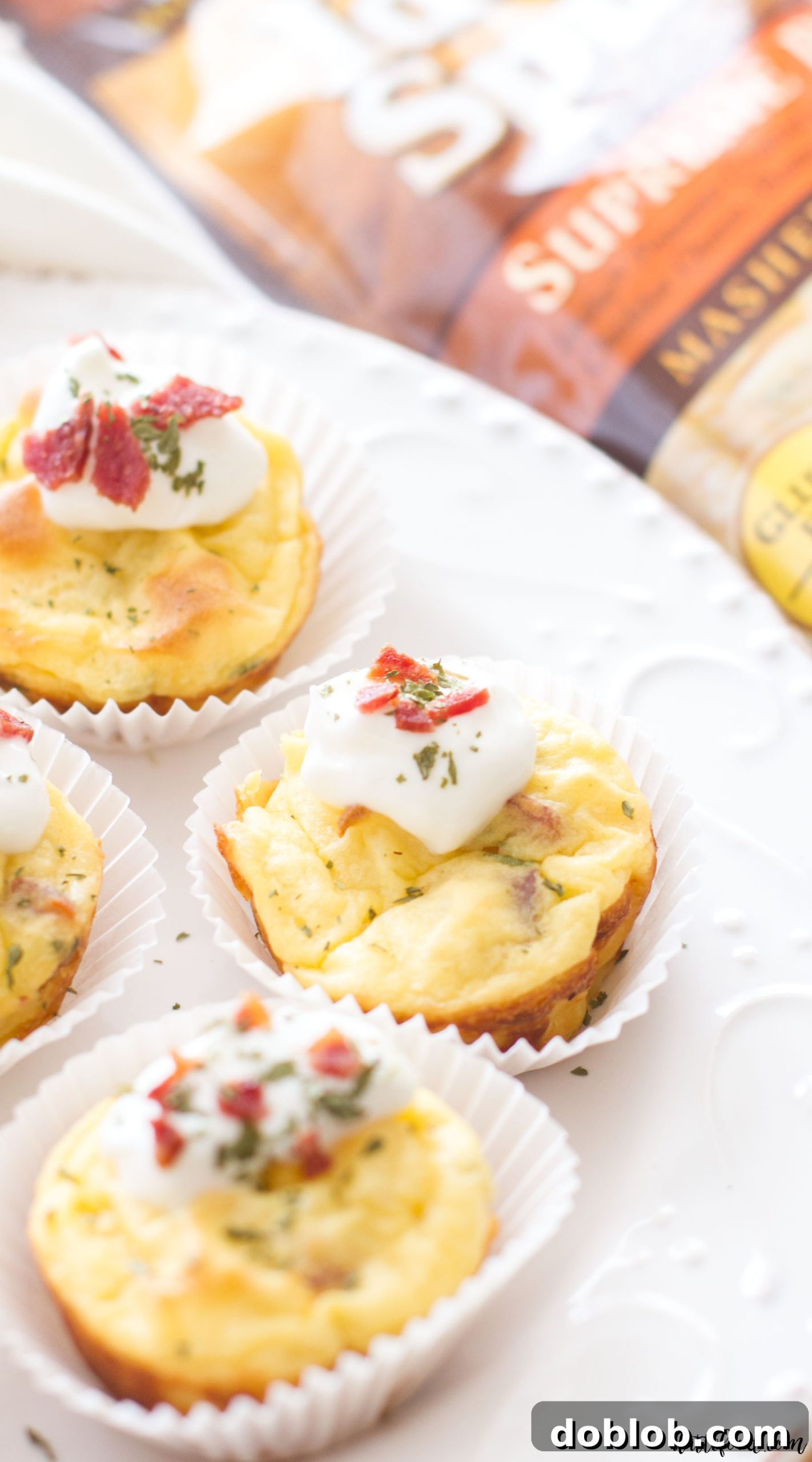A serving of bacon and chive mashed potato puffs, garnished with extra chives, ready to be enjoyed as a savory snack.