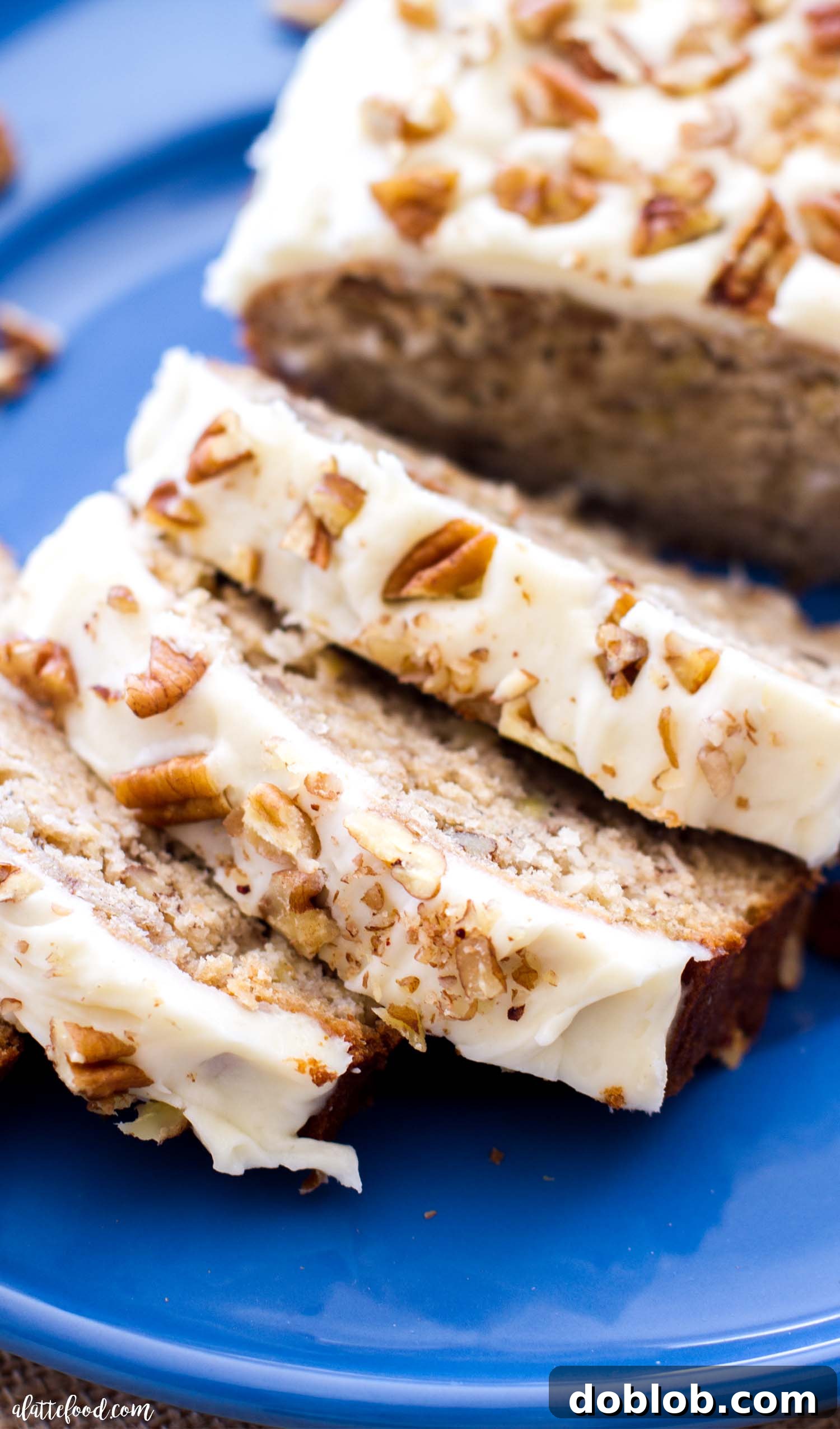 Golden Banana Walnut Gems 2 Moist hummingbird bread topped with a luscious cream cheese frosting, showcasing its inviting texture and delicious Southern flavors.