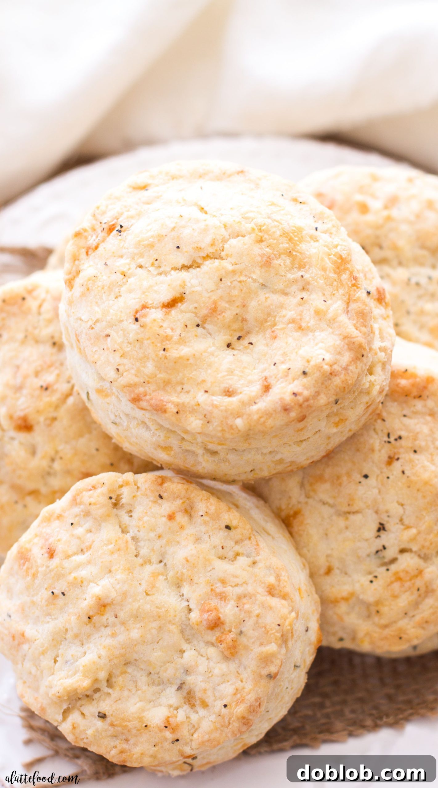Spicy Pepper Jack Herb Biscuits 7 A basket of freshly baked pepper jack and herb biscuits, arranged invitingly on a patterned towel.