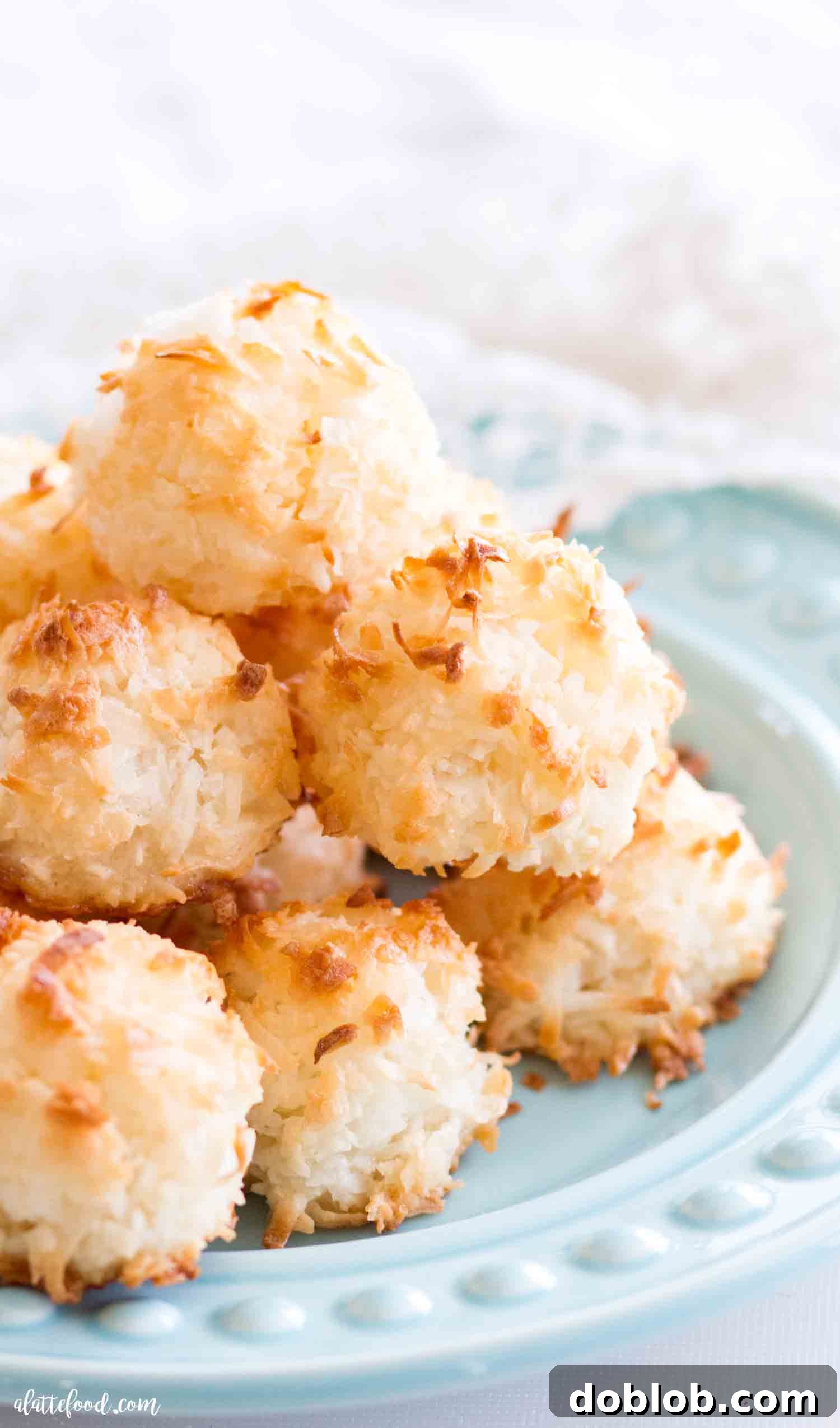 The best coconut macaroons begin with egg whites, sugar and coconut. These homemade macaroons are gluten free and are so simple to make (even without sweetened condensed milk!). A perfect dessert! #dessert #cookie #coconut #macaroon Perfectly stacked gluten-free coconut macaroons on a plate, showcasing their inviting texture