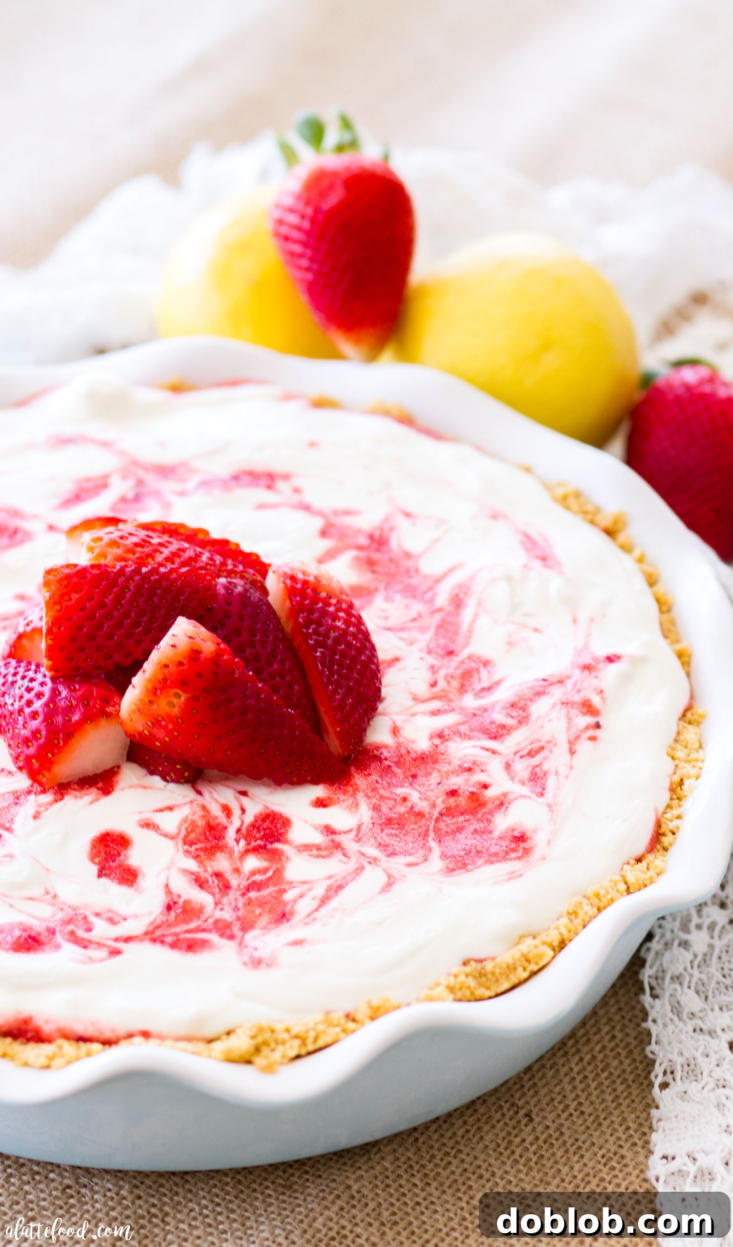 A vibrant slice of Strawberry Lemonade Icebox Pie with a graham cracker crust