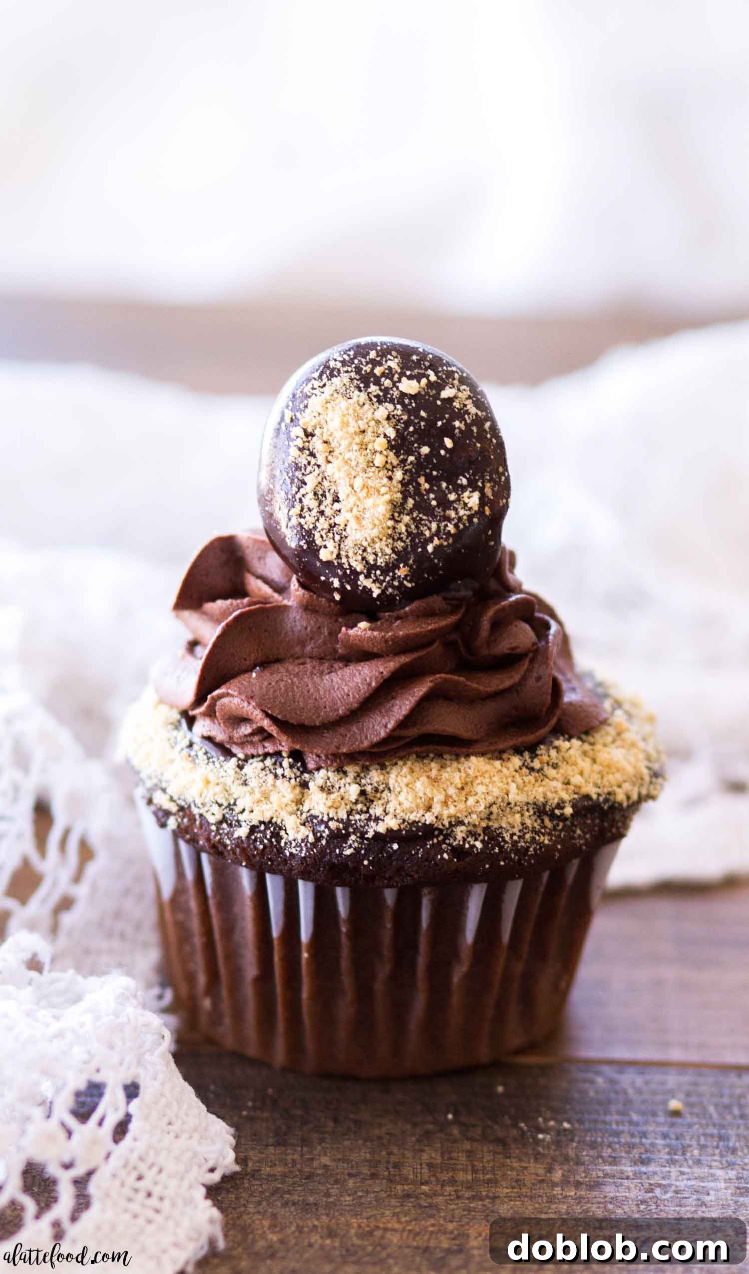 A single s'mores chocolate cupcake beautifully presented on a wooden platter