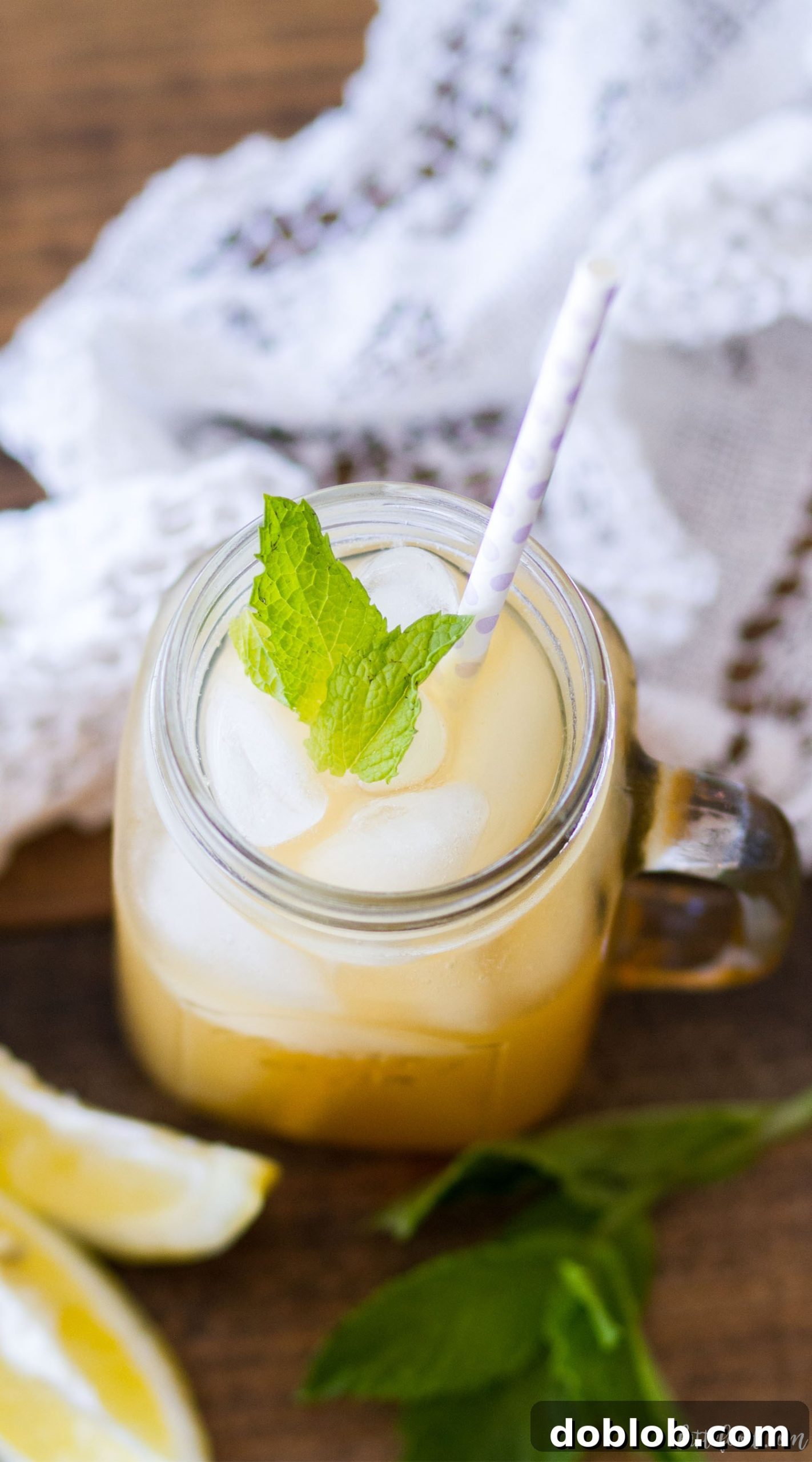 A refreshing pitcher of Iced Peach Green Tea with fresh peach slices and mint.