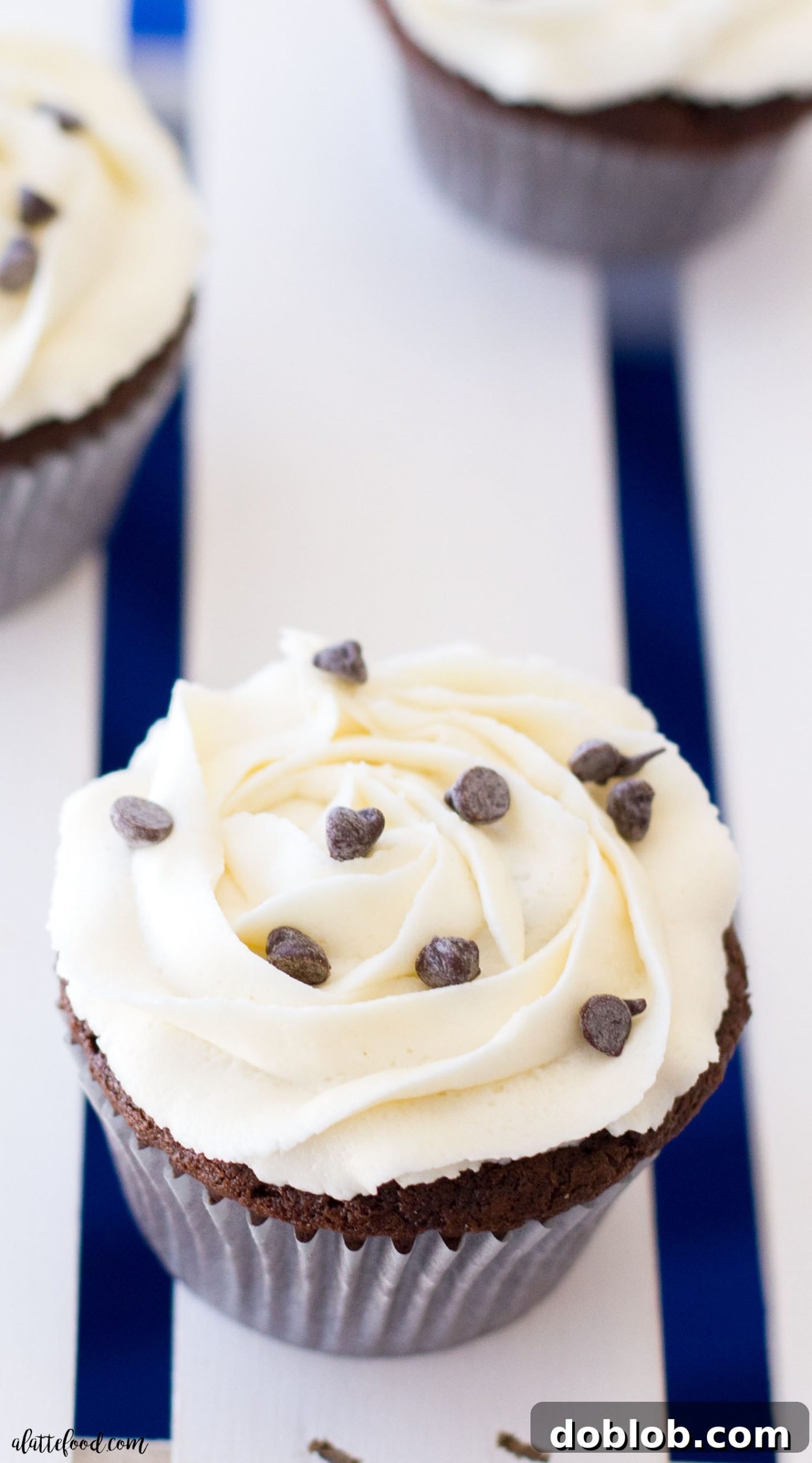 A freshly baked Oreo truffle stuffed chocolate cupcake, beautifully piped with vanilla buttercream and adorned with chocolate sprinkles, inviting you to take a bite.