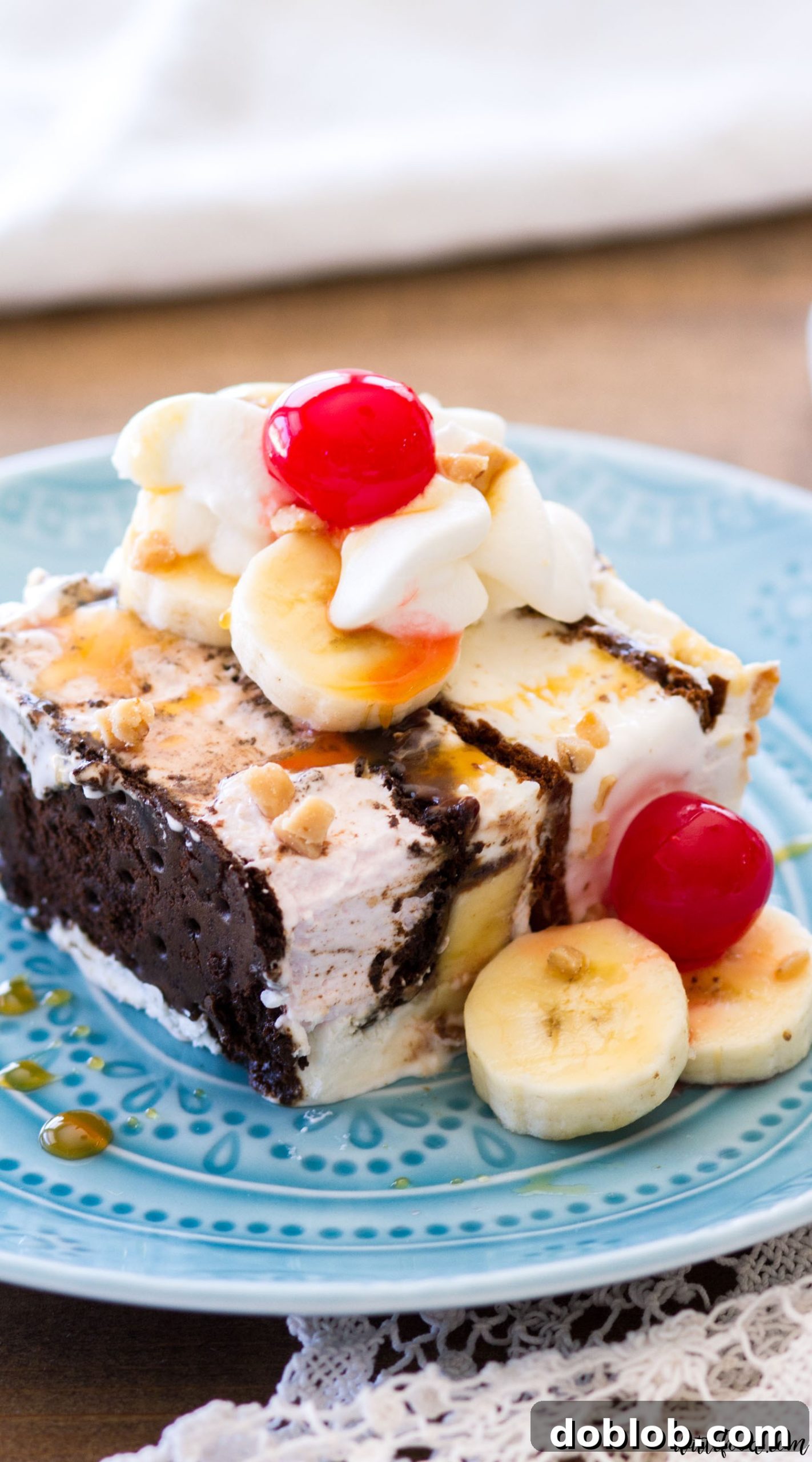 Finished Banana Split Ice Cream Sandwich Cake topped with whipped cream, sauces, and cherries.