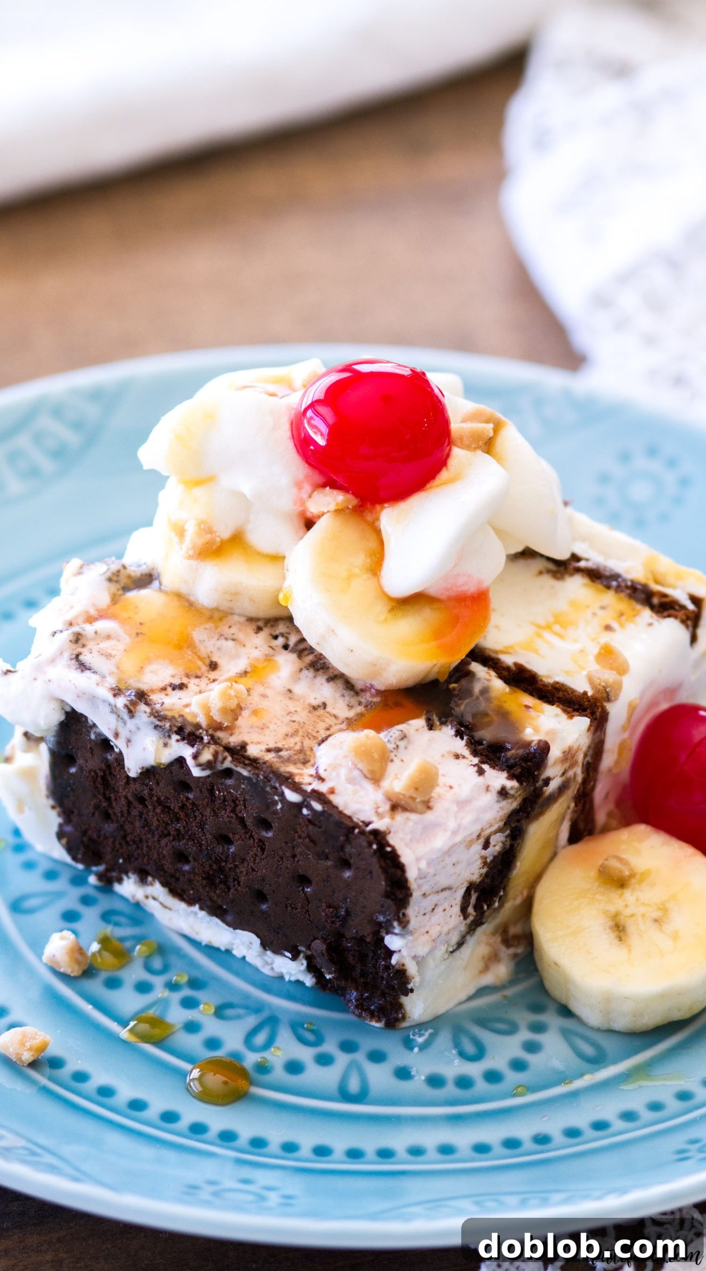This Banana Split Ice Cream Sandwich Cake is a fun twist on the classic banana split dessert. Ice Cream Sandwiches, bananas, caramel sauce, hot fudge, whipped cream, and cherries make up this super pretty ice cream dessert!