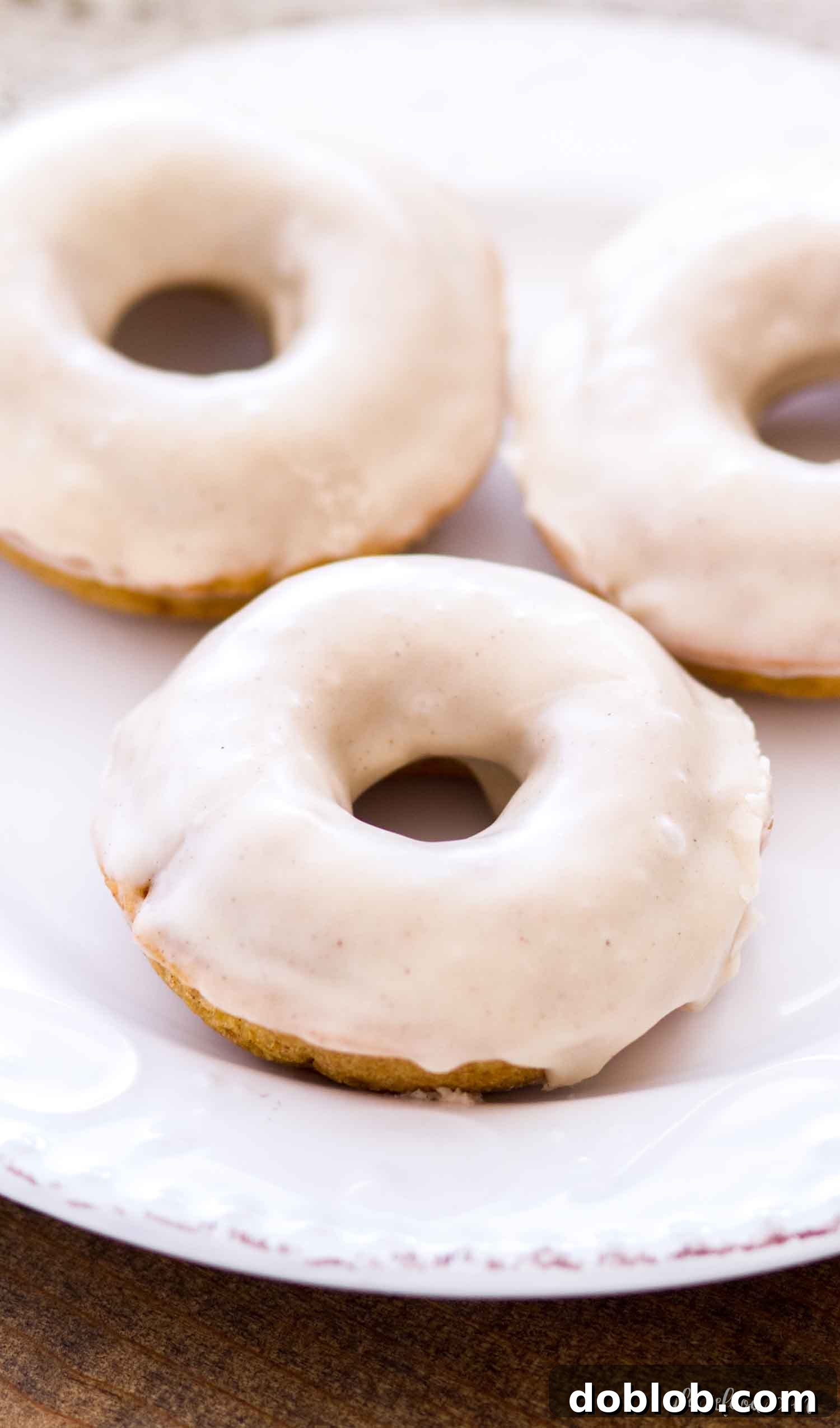 The Best Baked Buttermilk Pumpkin Donut Recipe Delicious baked Buttermilk Pumpkin Donuts arranged beautifully on a white plate, showcasing their inviting texture and generous glaze.