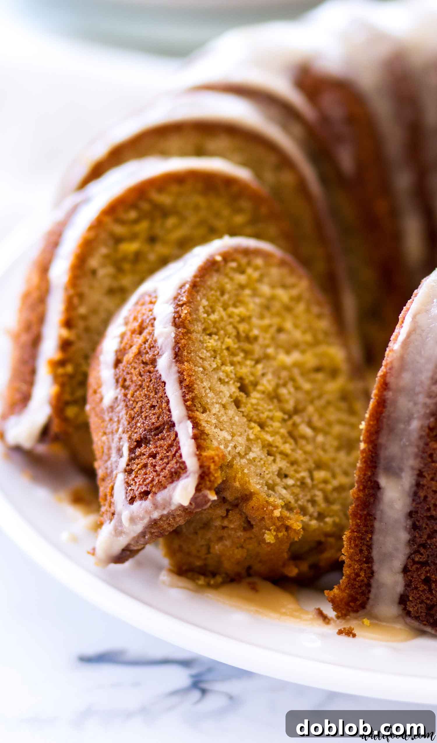 Exquisite Vanilla Pumpkin Bundt Cake with Maple Icing Slices of elegant Vanilla Pumpkin Bundt Cake drizzled with sweet maple icing, presented beautifully, a perfect fall dessert.