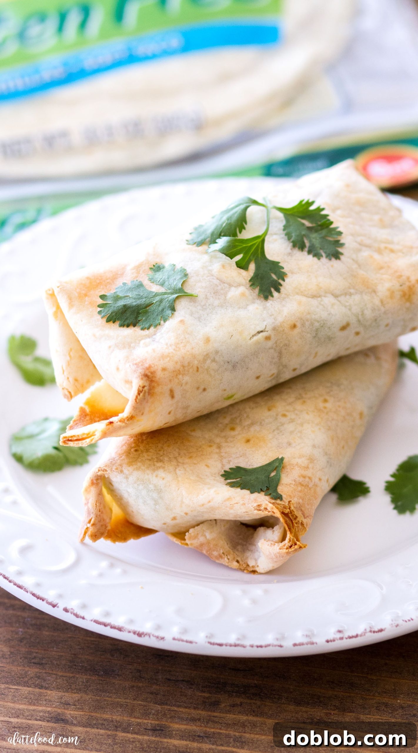 Hearty Oven-Baked Chicken & Avocado Burritos 4 A stack of golden brown Baked Avocado Chicken Burritos on a baking sheet, showcasing their perfectly baked exterior.