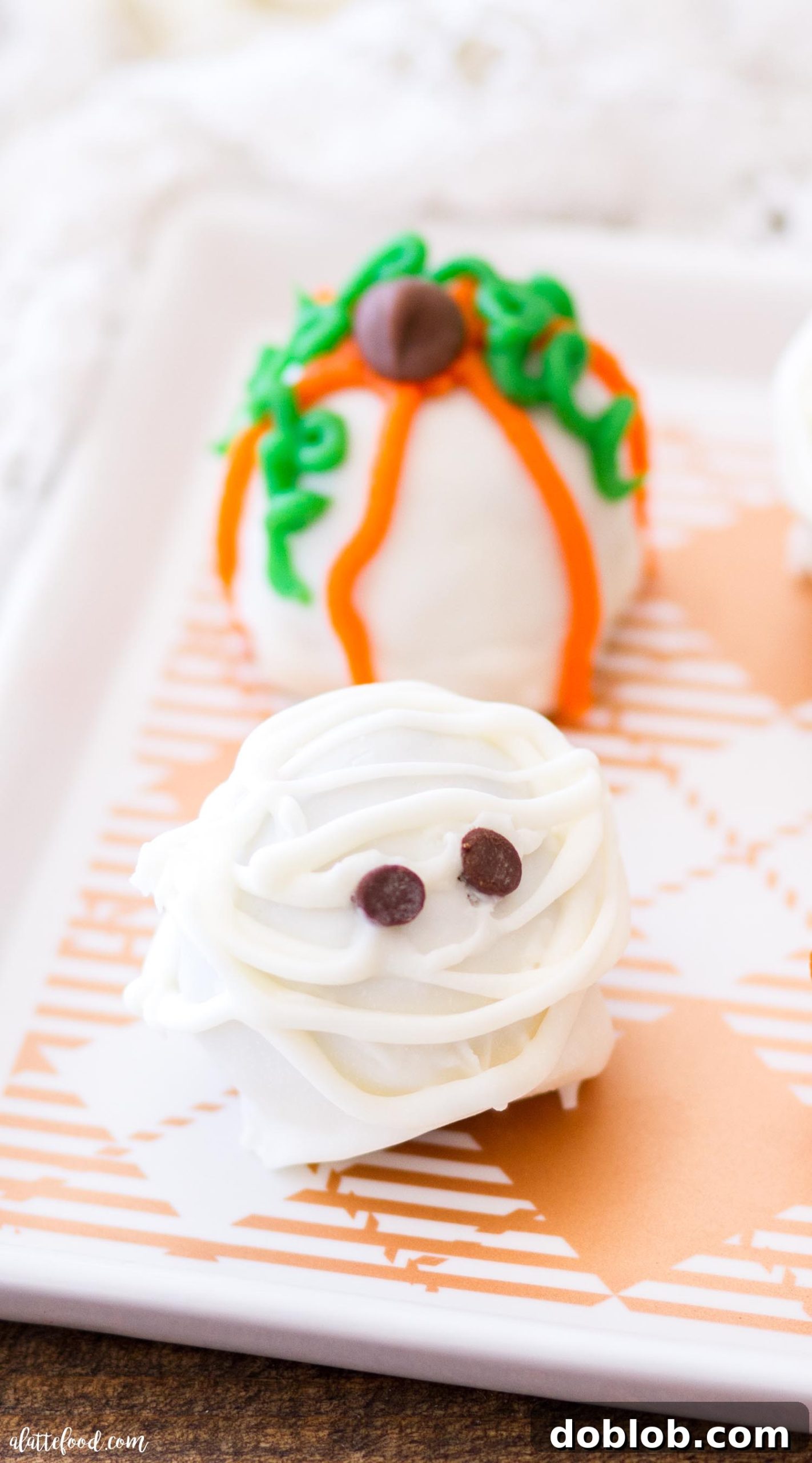 Close-up of Halloween Cookie Truffles featuring mummy and pumpkin designs, showing their creamy interior.
