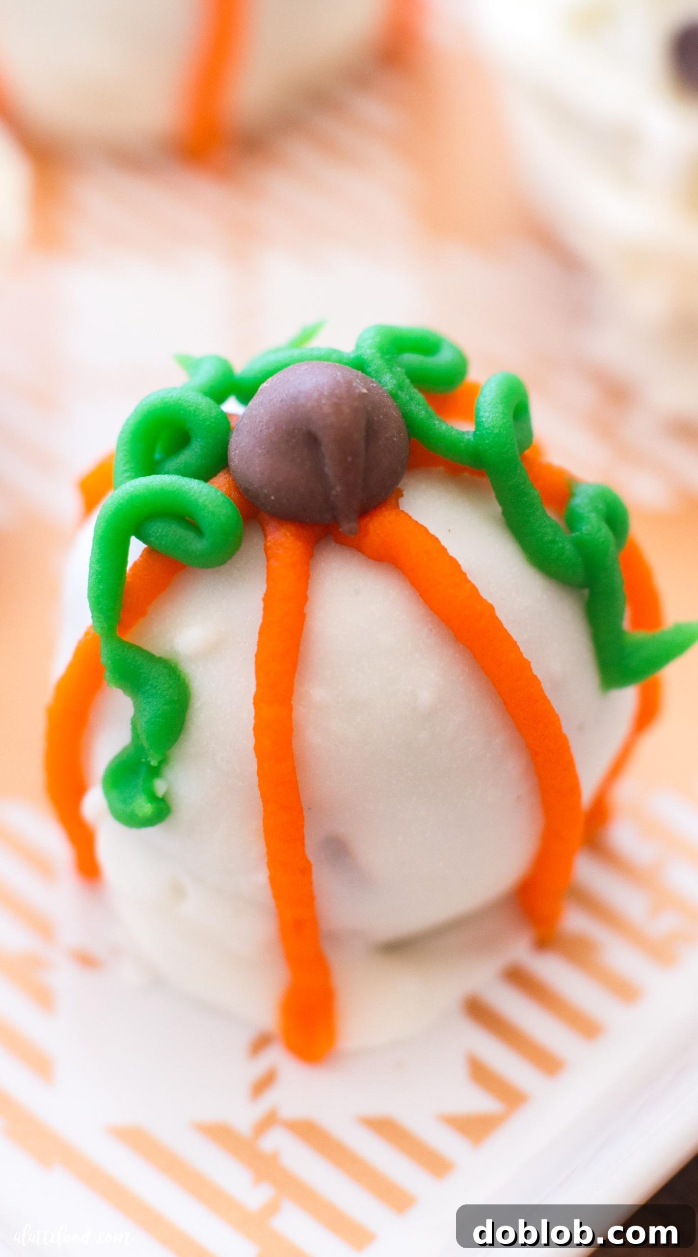 A festive display of Halloween Cookie Truffles, some decorated as mummies with mini chocolate chip eyes, others as pumpkins with frosting details.