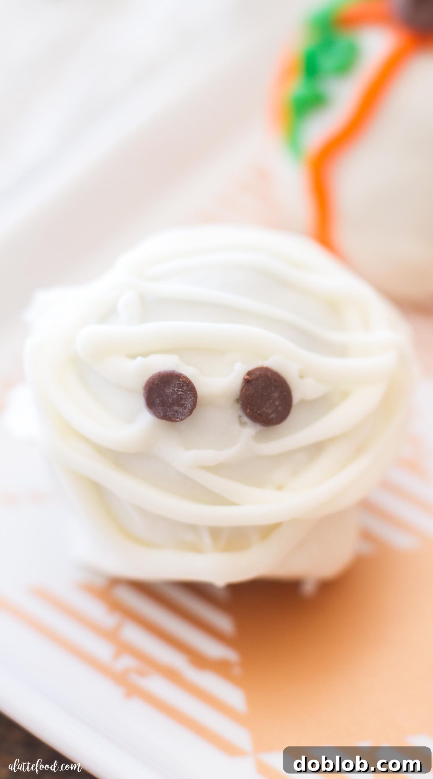 A close-up of a partially decorated Halloween Cookie Truffle before dipping, showing the cookie and cream cheese mixture.