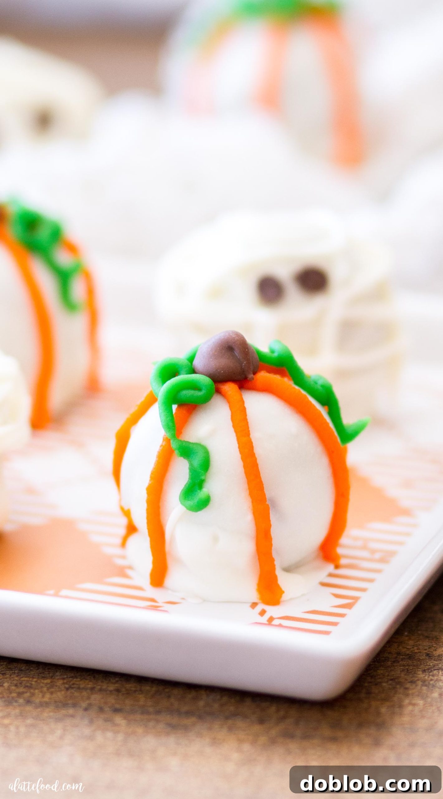 A tray of Halloween Cookie Truffles, some dipped in white almond bark, others awaiting decoration as mummies and pumpkins.