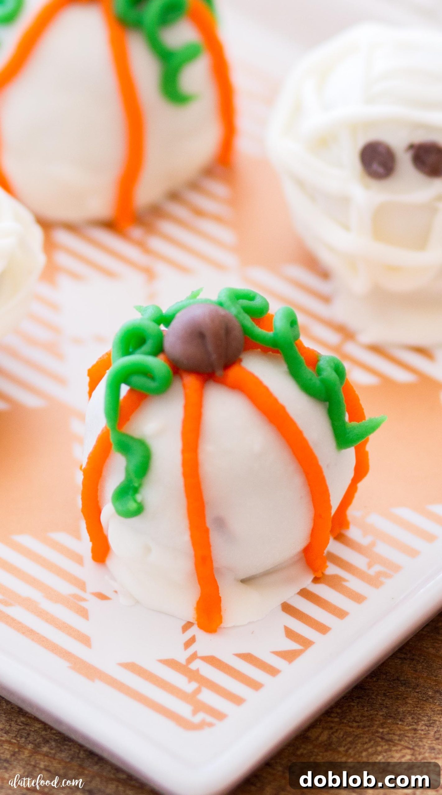 A collection of decorated Halloween Cookie Truffles, showcasing both mummy and pumpkin designs, ready to be served.