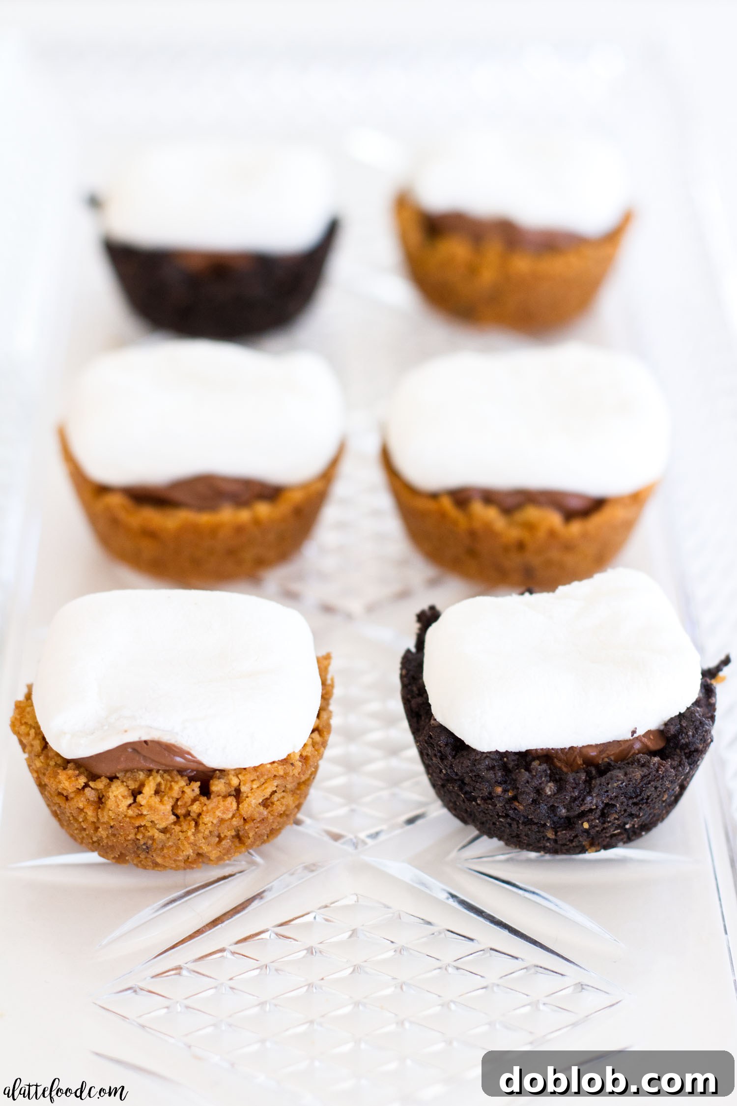 Mini S'mores Bites: All the flavors of the classic campfire dessert are combined into one perfect bite! A top-down view of several Mini S'mores Bites arranged on a wooden board, showcasing their perfect miniature size and delicious appearance.