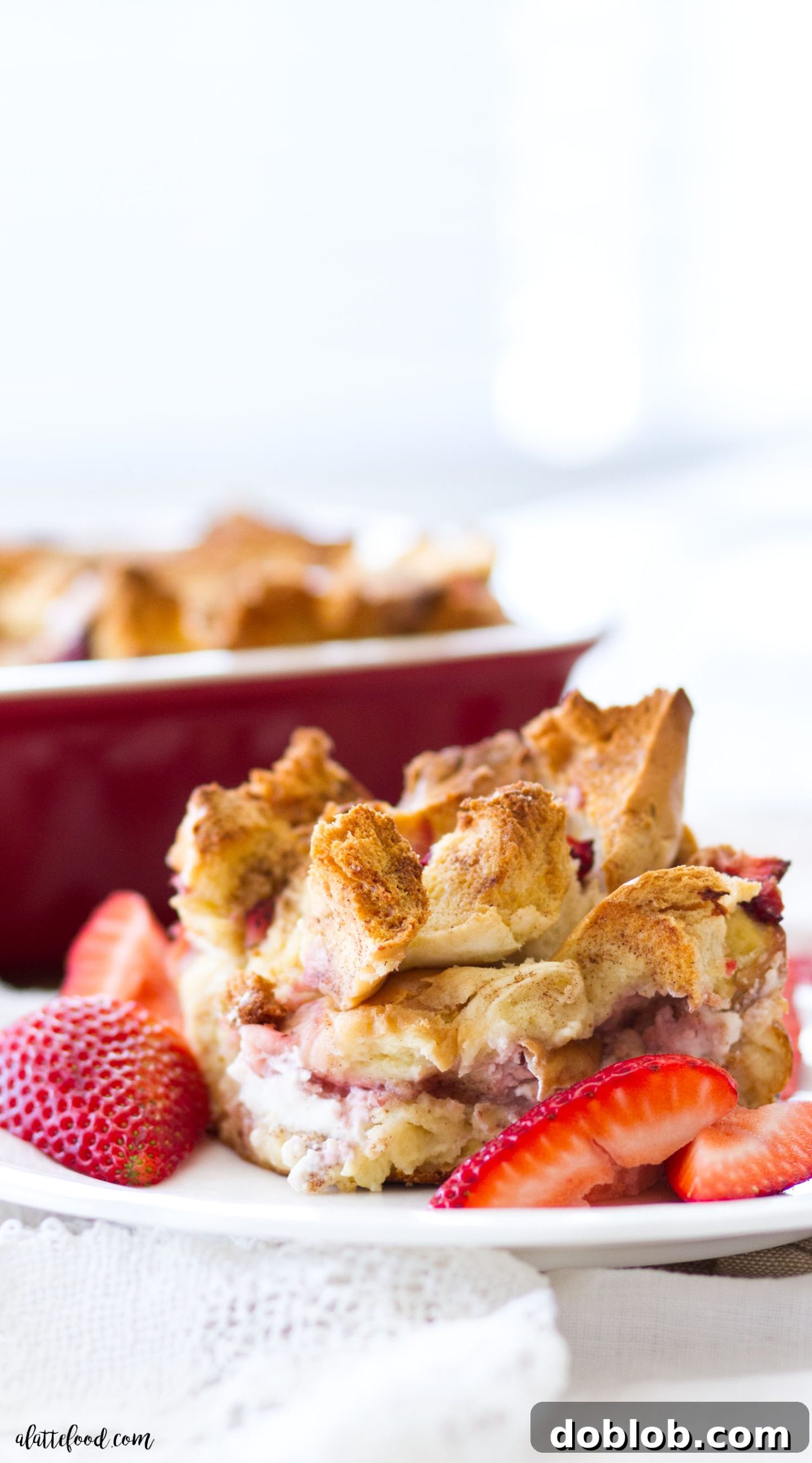 A baking dish filled with Bagel and Cream Cheese Strawberry French Toast Casserole, ready to be soaked in the egg custard and refrigerated for an easy brunch.