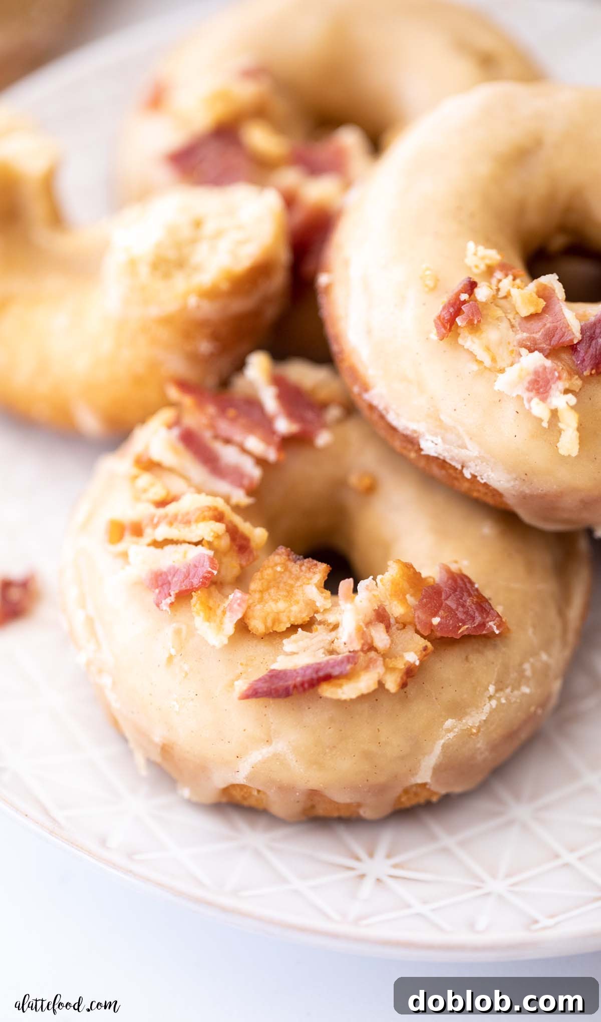 Maple glazed donut with crispy bacon crumbles on a gray plate, a favorite fall breakfast.