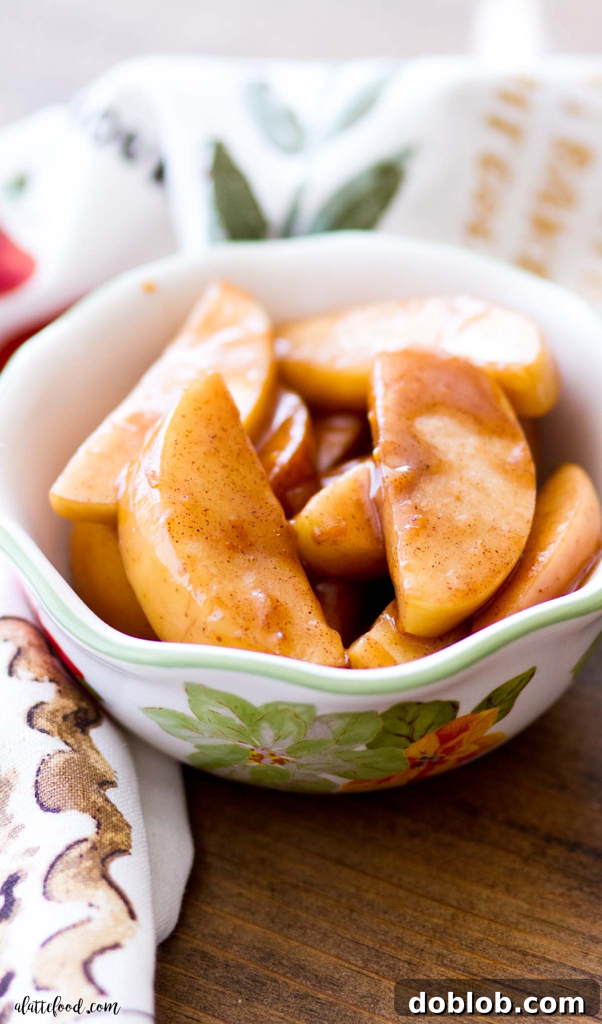Baked cinnamon apples in a green and white bowl, perfect as a dessert or topping. Refined sugar-free and gluten-free.