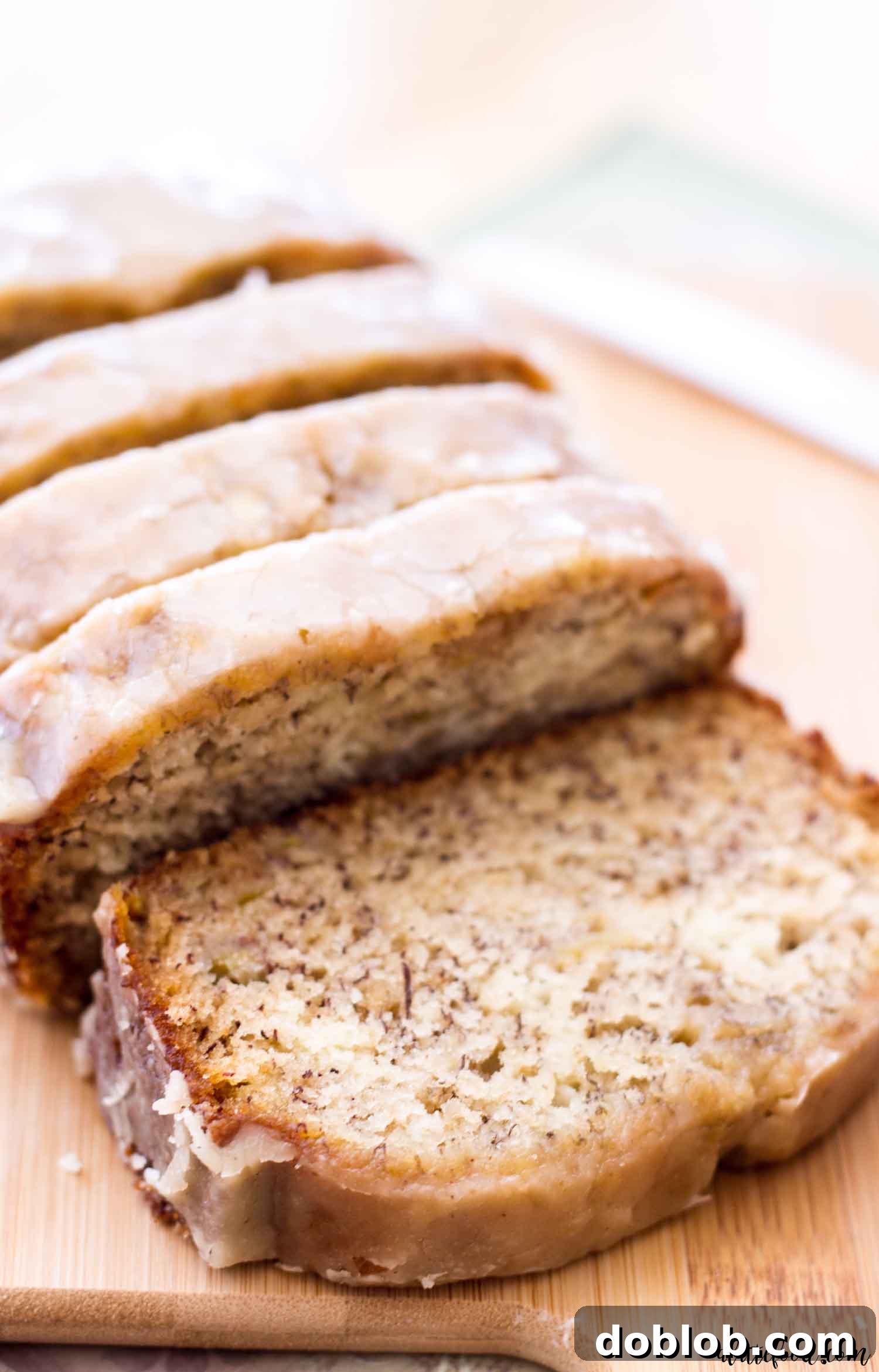 Loaf of maple glazed banana bread, sliced, a cozy fall dessert.