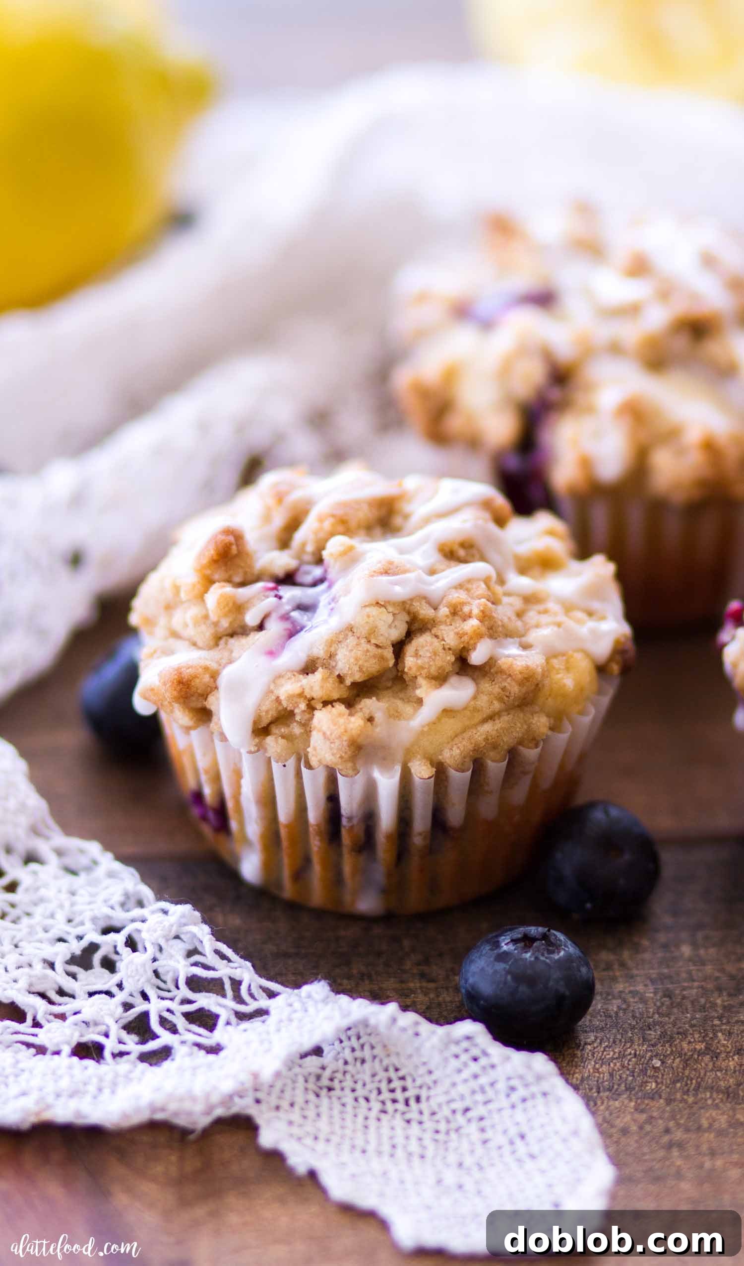 crumb cake topped lemon blueberry muffin with glaze