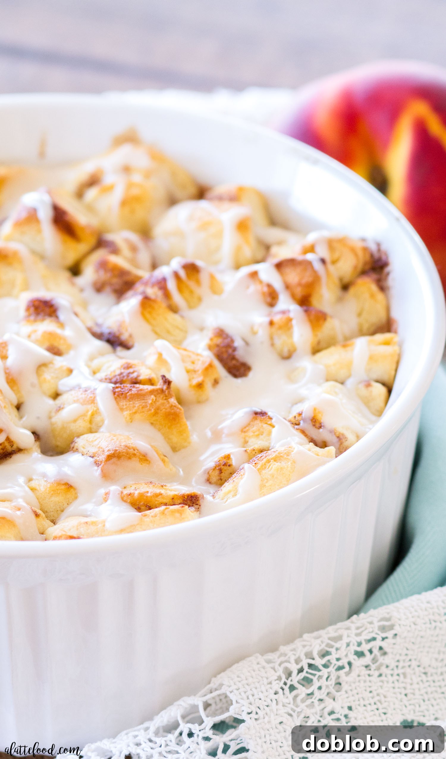Quick and Easy Cinnamon Roll Peach Cobbler made with fresh peaches and pre-made cinnamon roll dough, topped with vanilla glaze.