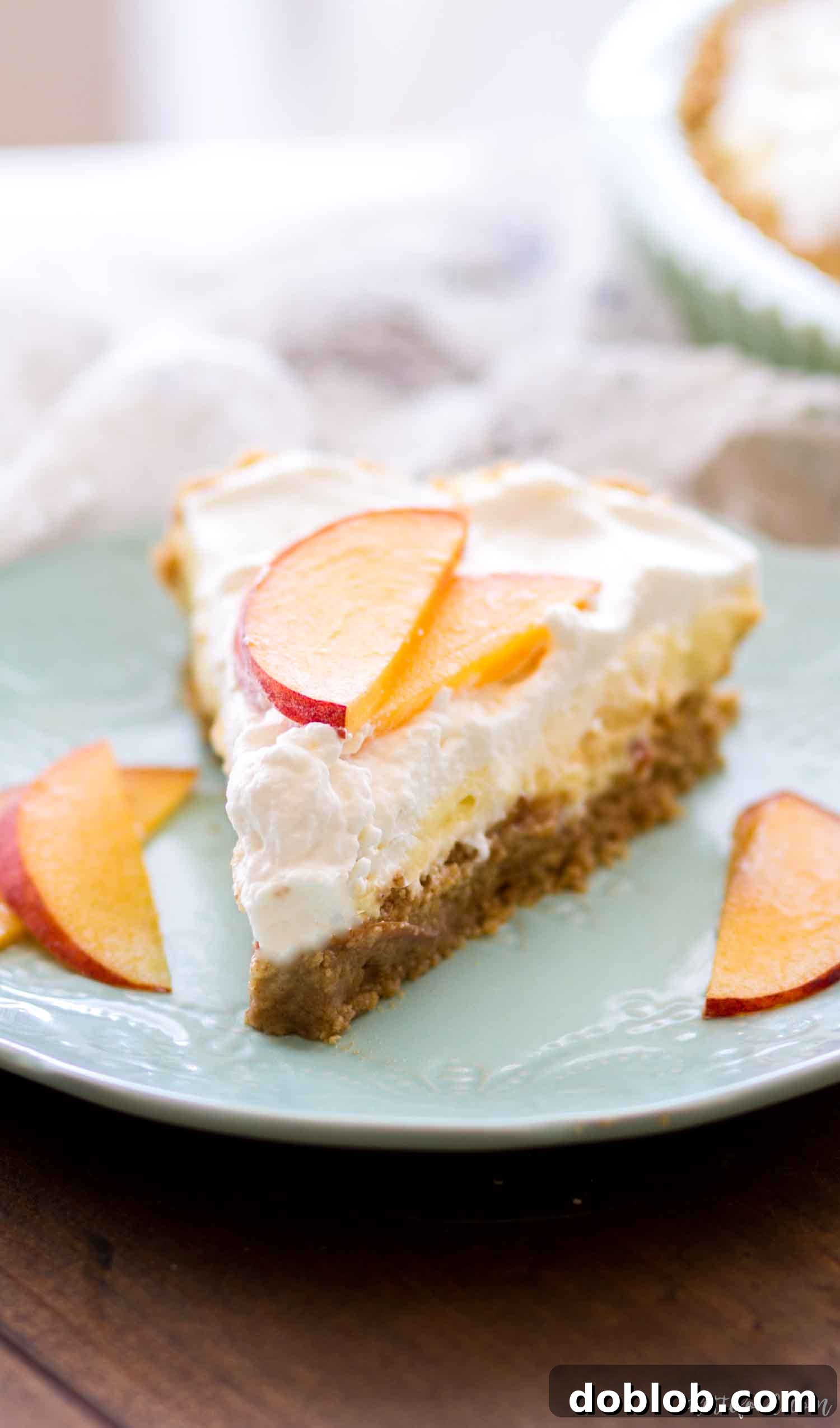 Close-up of a slice of No Bake Peach Cream Pie, showing layers of fluffy cream and tender fresh peaches.