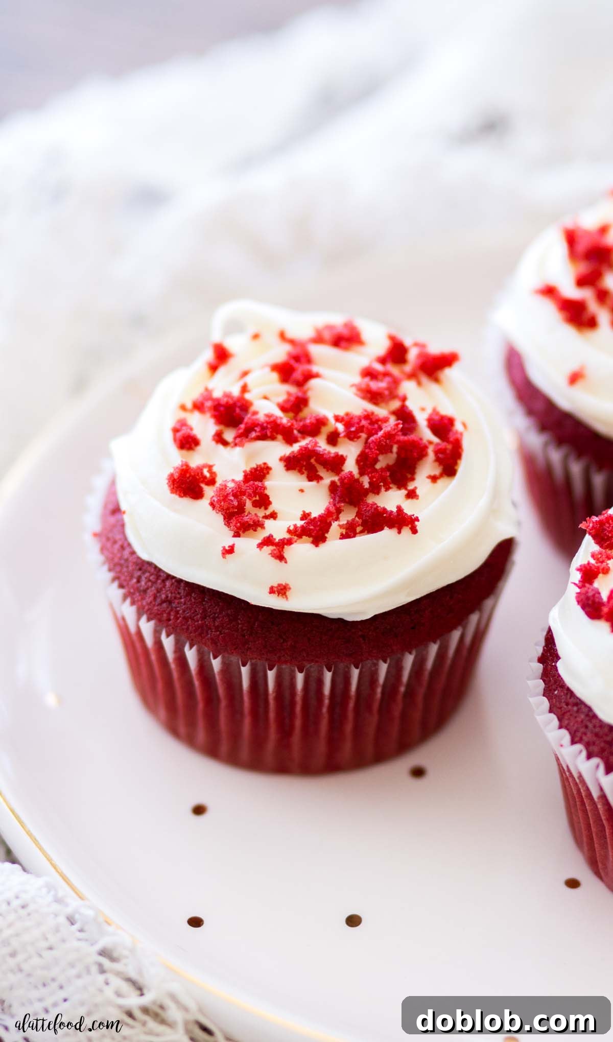 Heavenly Red Velvet Cupcakes 2 fluffy homemade red velvet cupcake with tangy cream cheese frosting on polka dot plate