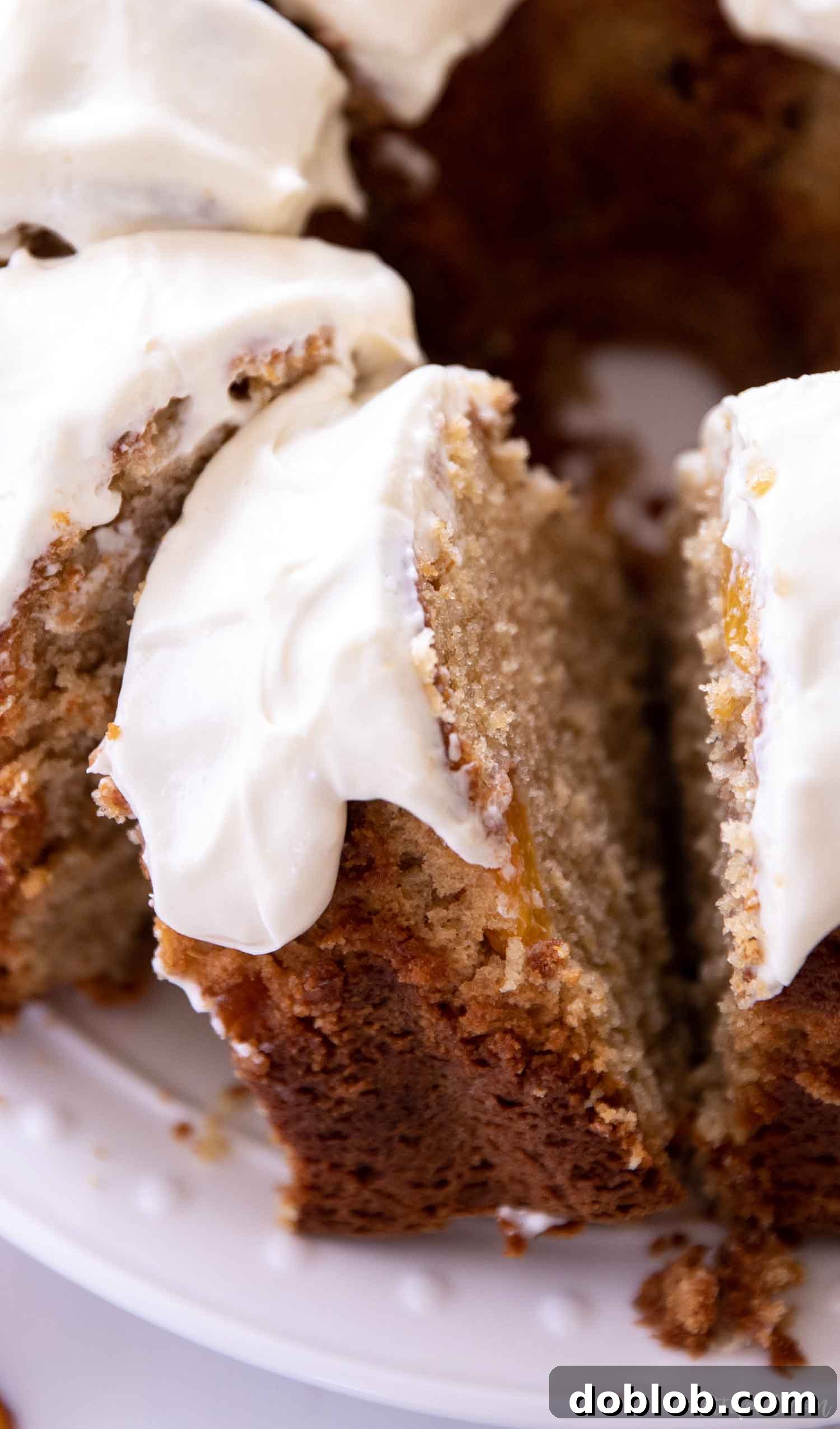 Multiple slices of peach cake drizzled with a thick cream cheese glaze, invitingly presented.