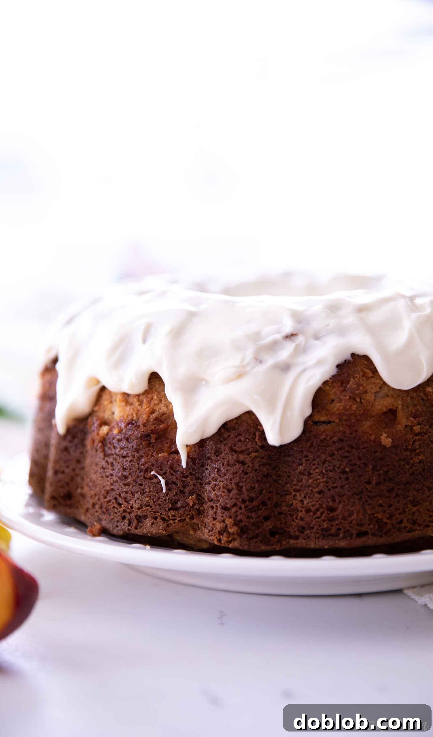A beautifully glazed peach bundt cake, showcasing the perfect texture and inviting golden-brown crust.
