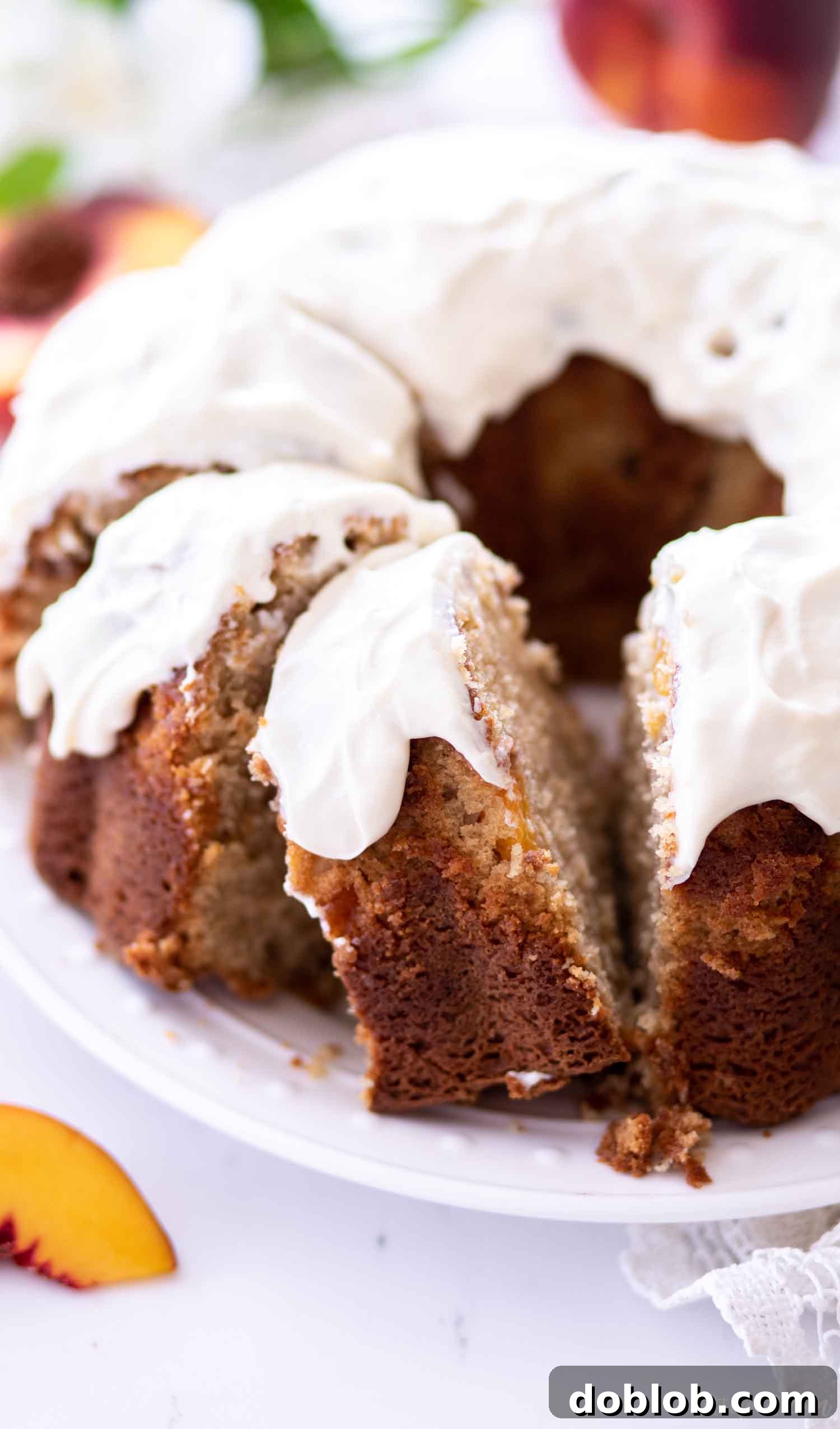 A slice of sour cream pound cake with peaches on a plate, highlighting its moist texture.