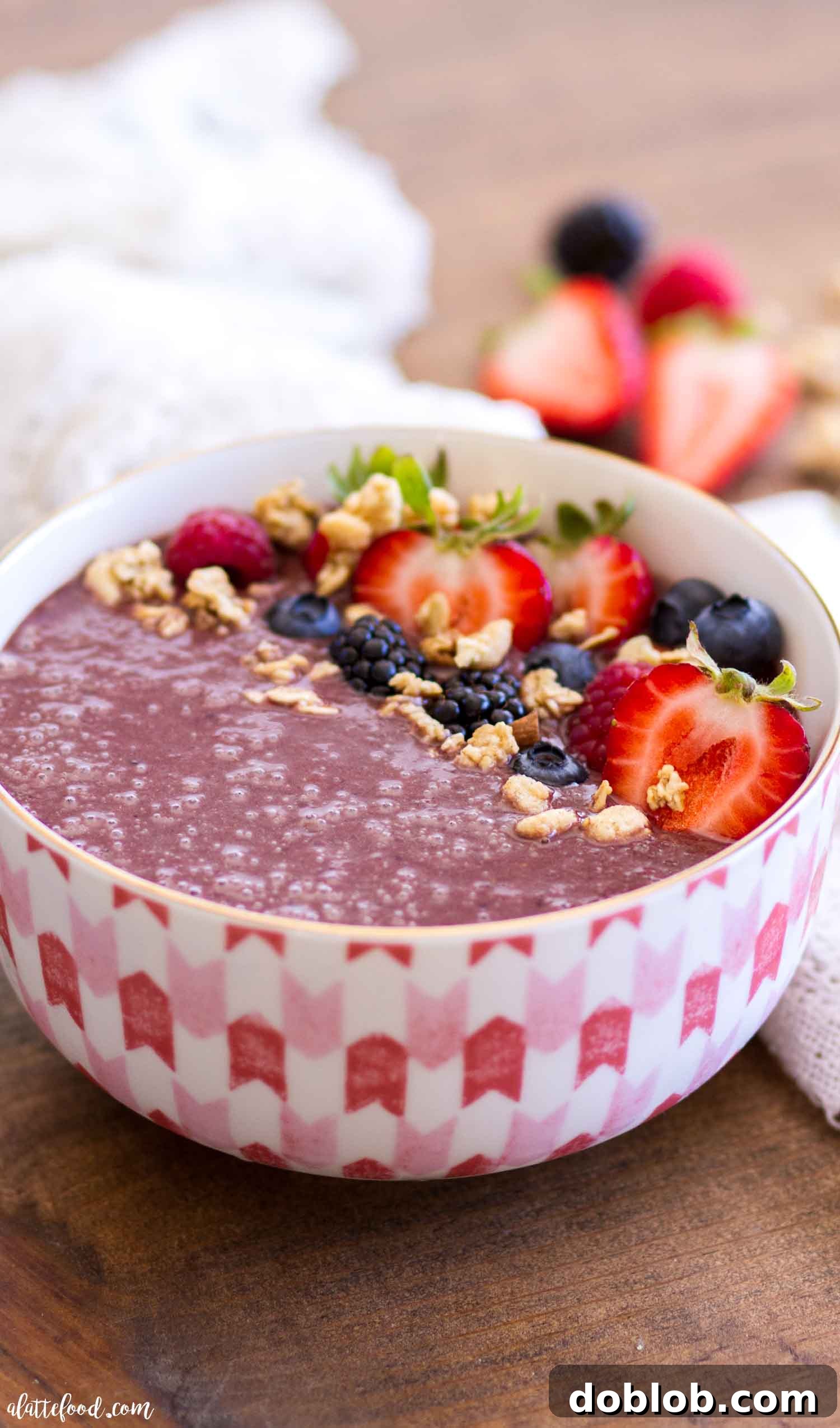 Easy homemade Açaí bowl, artfully arranged with fresh blueberries, sliced strawberries, toasted coconut flakes, and golden granola. The thick, creamy Açaí base fills the bowl, suggesting a refreshing and nutritious meal. Keywords: homemade Acai bowl, easy recipe, healthy breakfast, berries, granola, coconut flakes, refined sugar free.