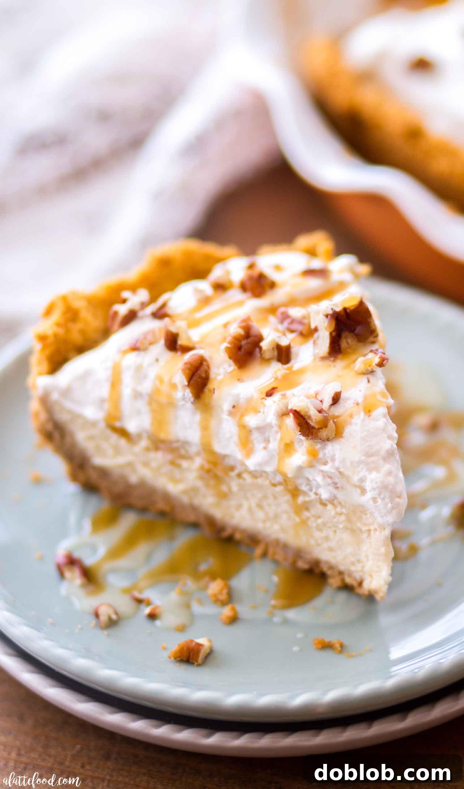 A close-up of a Homemade Caramel Cheesecake with a perfect pecan graham cracker crust, highlighting the smooth, creamy texture of the filling before it's adorned.